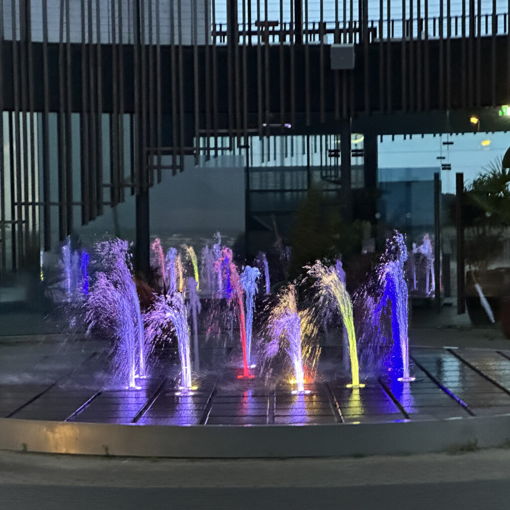 Värviline purskkaev tuledega õhtuses valguses.