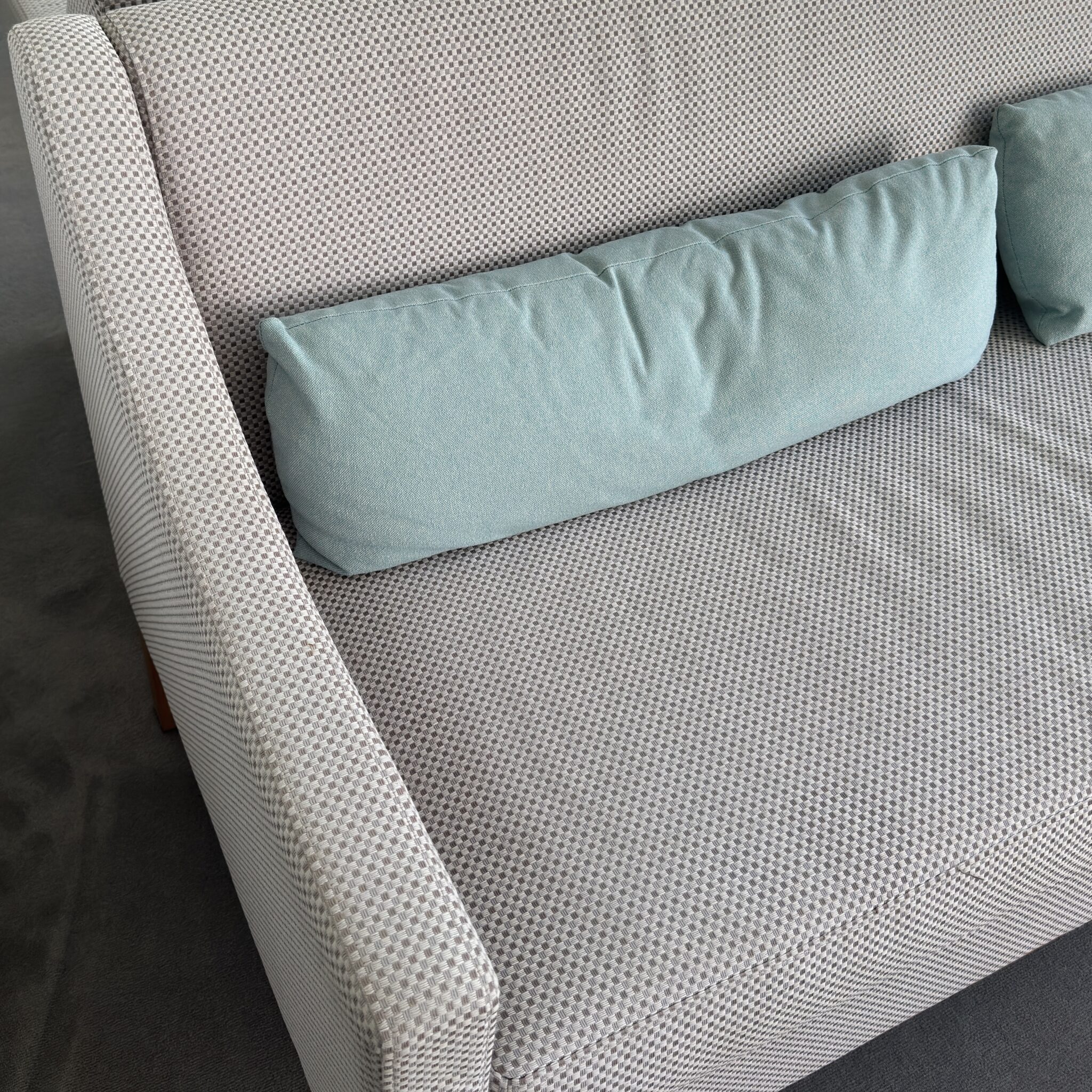 Hele sinine padi mustrilisel diivanil.