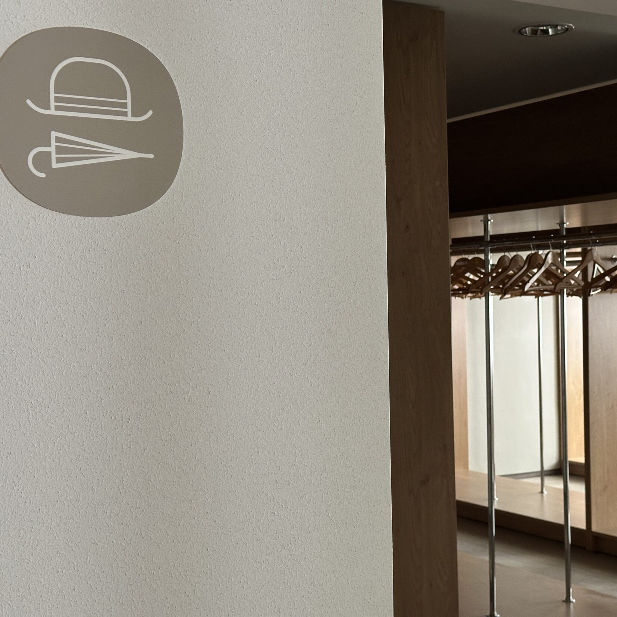 Silt riidepuu ja vihmavarju kujutisega viitab garderoobile.