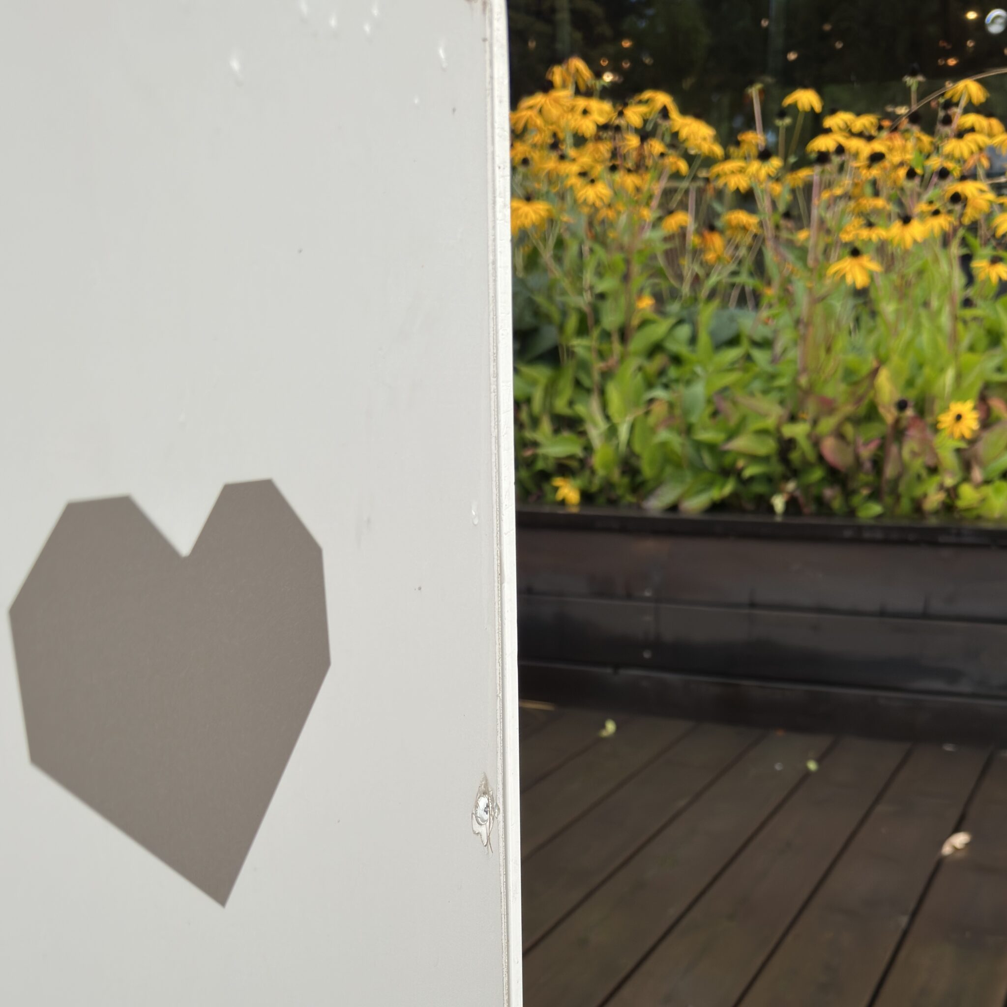 Südamekujuline ava uksel, taustal lilled.