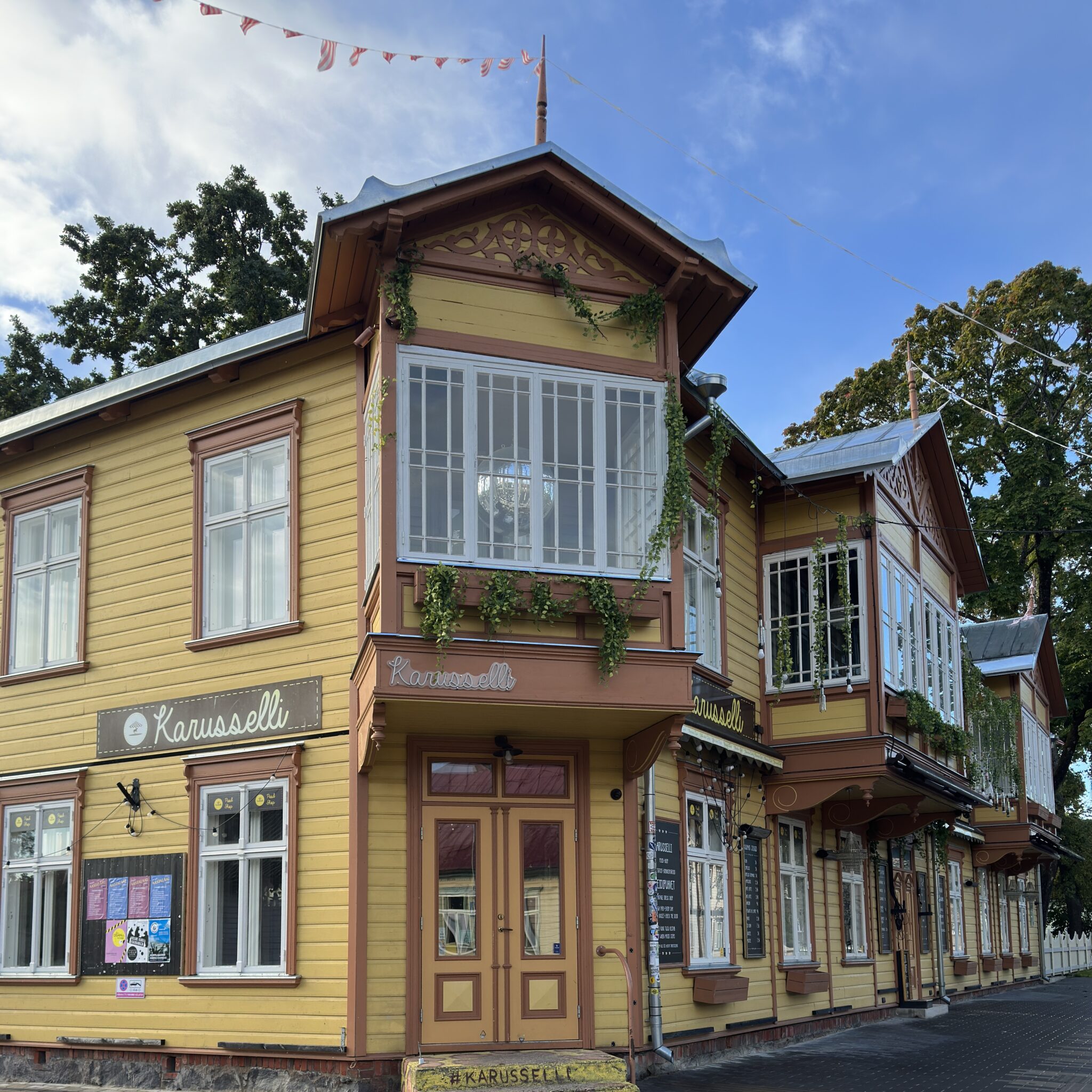 Võluv kollane puithoone sildiga „Karusselli”.