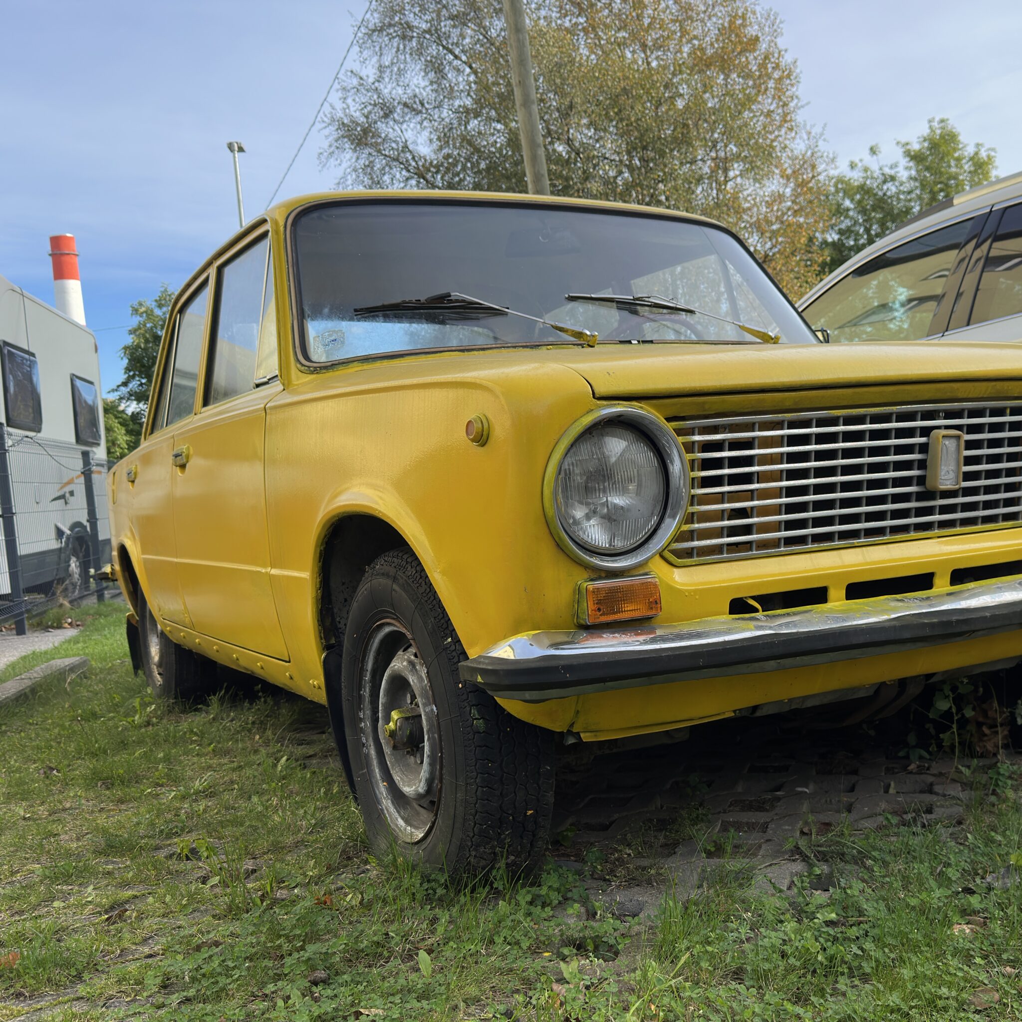 Kollane retroauto oranži esitule ja punase korstnaga.