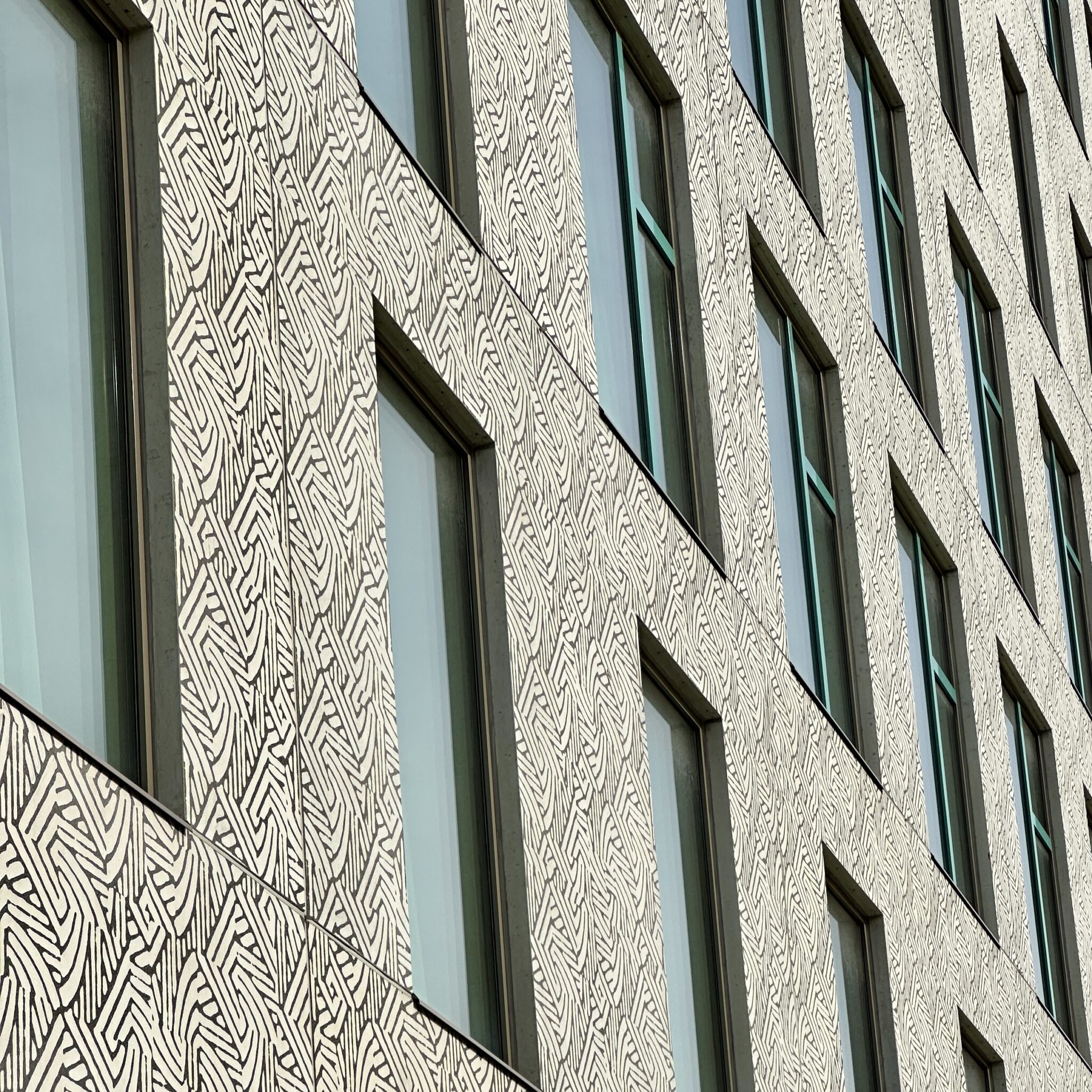 Kaasaegne hoone geomeetriliste mustrite ja akendega fassaadil.