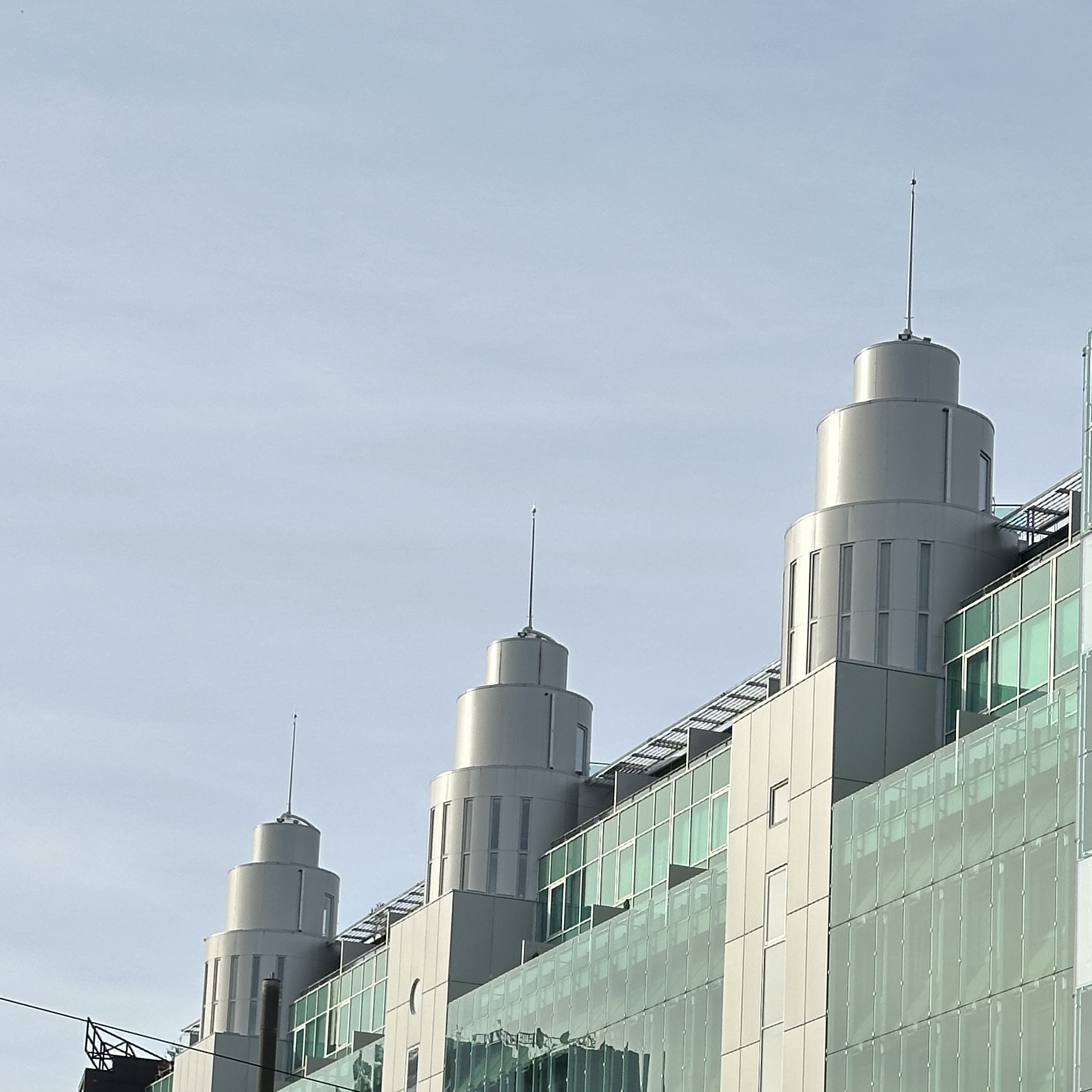 Kaasaegne pilvelõhkuja kõrgete tornide ja klaasfassaadiga.