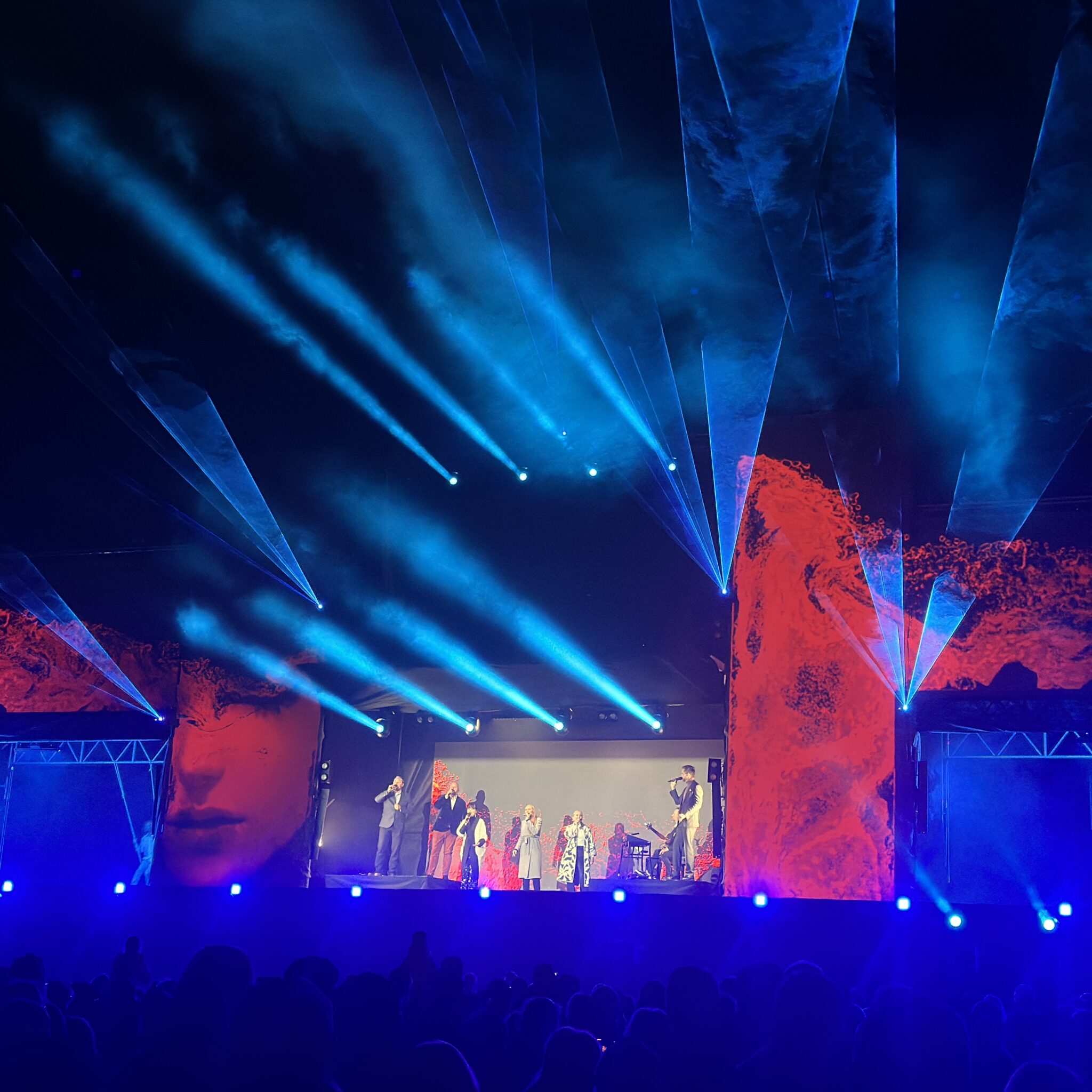 Elav lava siniste ja punaste tuledega, esinejad ja suur ekraan.