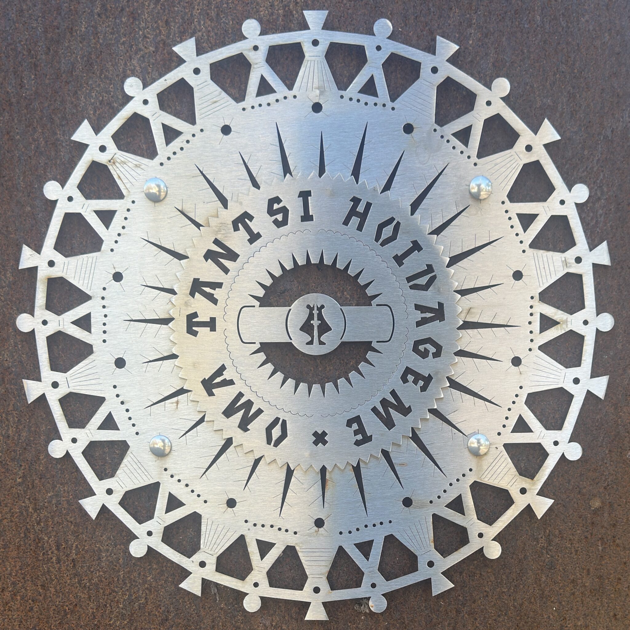 Ümmargune metallplaat detailse mustri ja tekstiga.