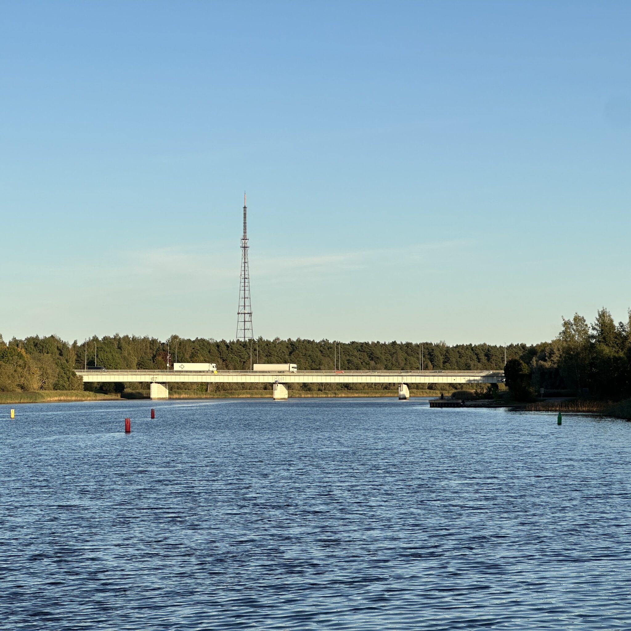 Sild ületab rahuliku järve, kauguses kõrge torn.