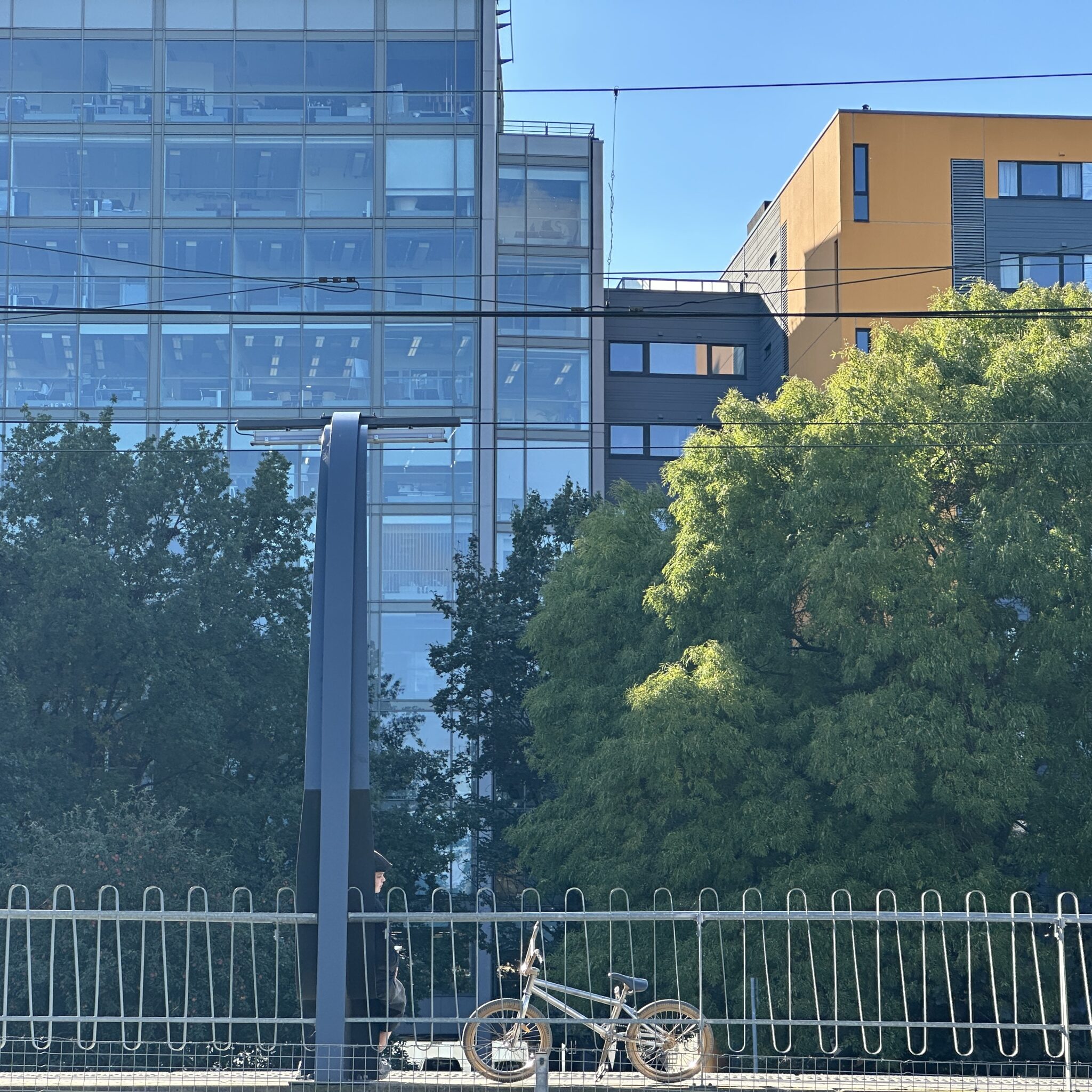 Jalgratas on pargitud aia najale kaasaegse hoone ees.