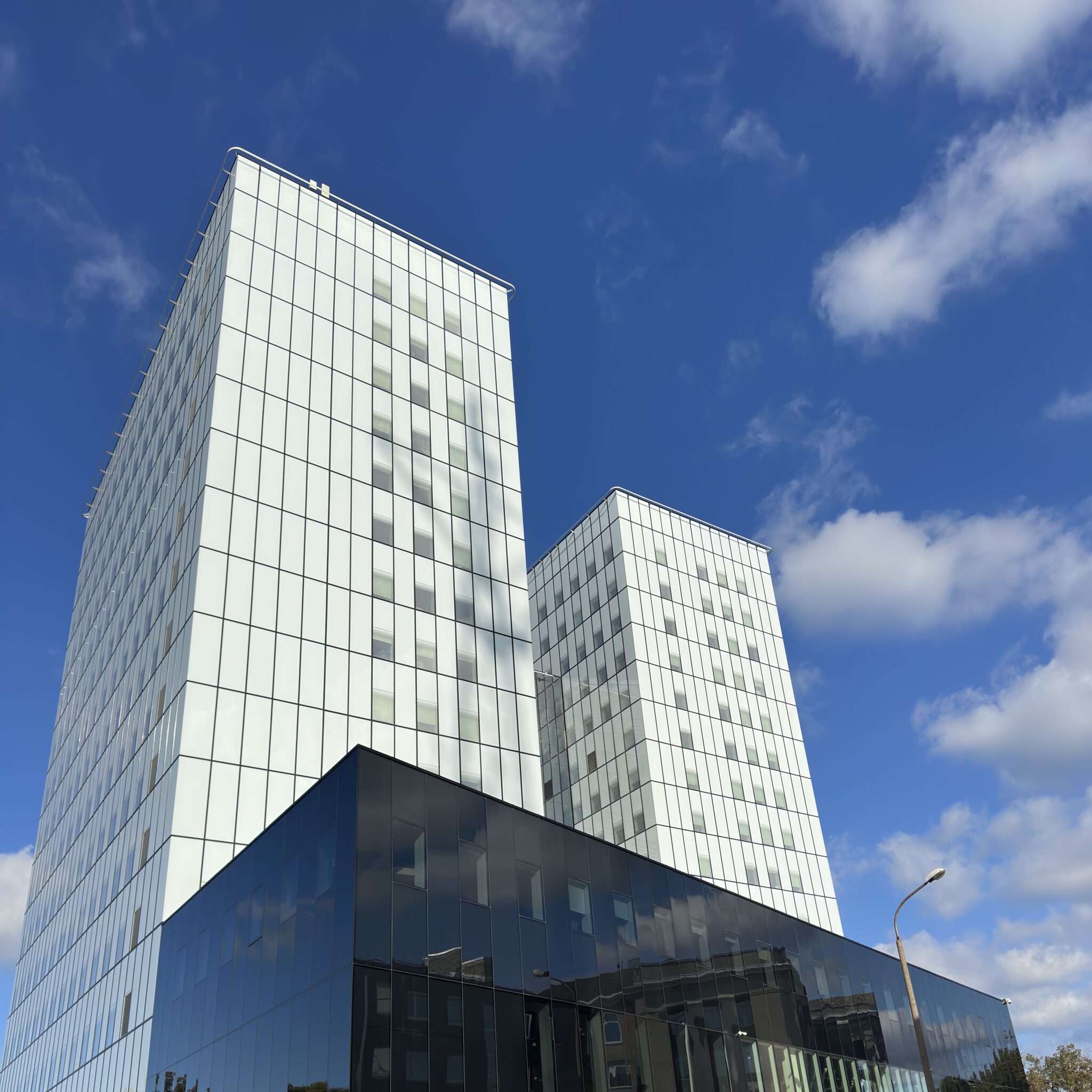 Kaks modernset pilvelõhkujat sinise taeva taustal.