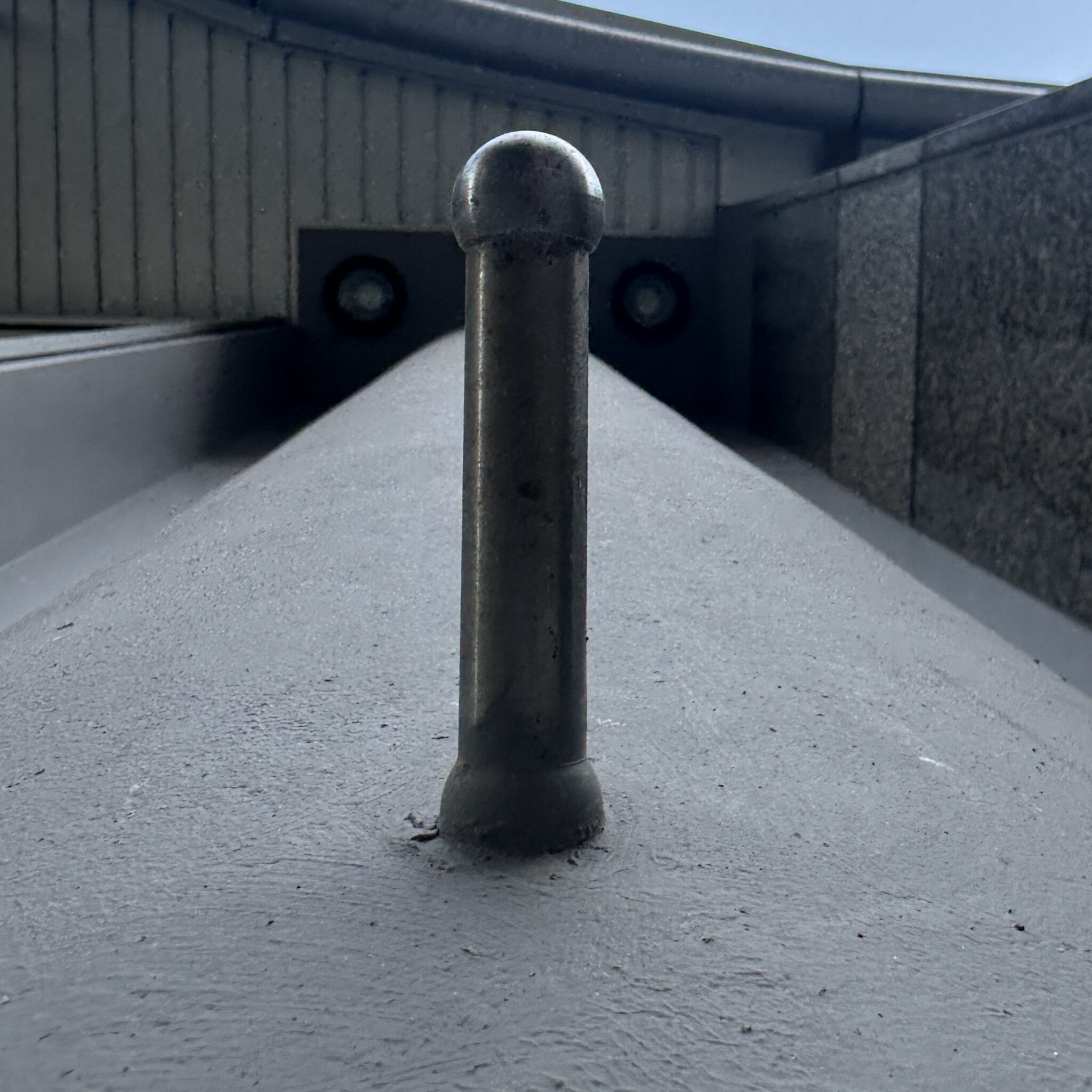 Metallpost seisab püsti betoonrajal.