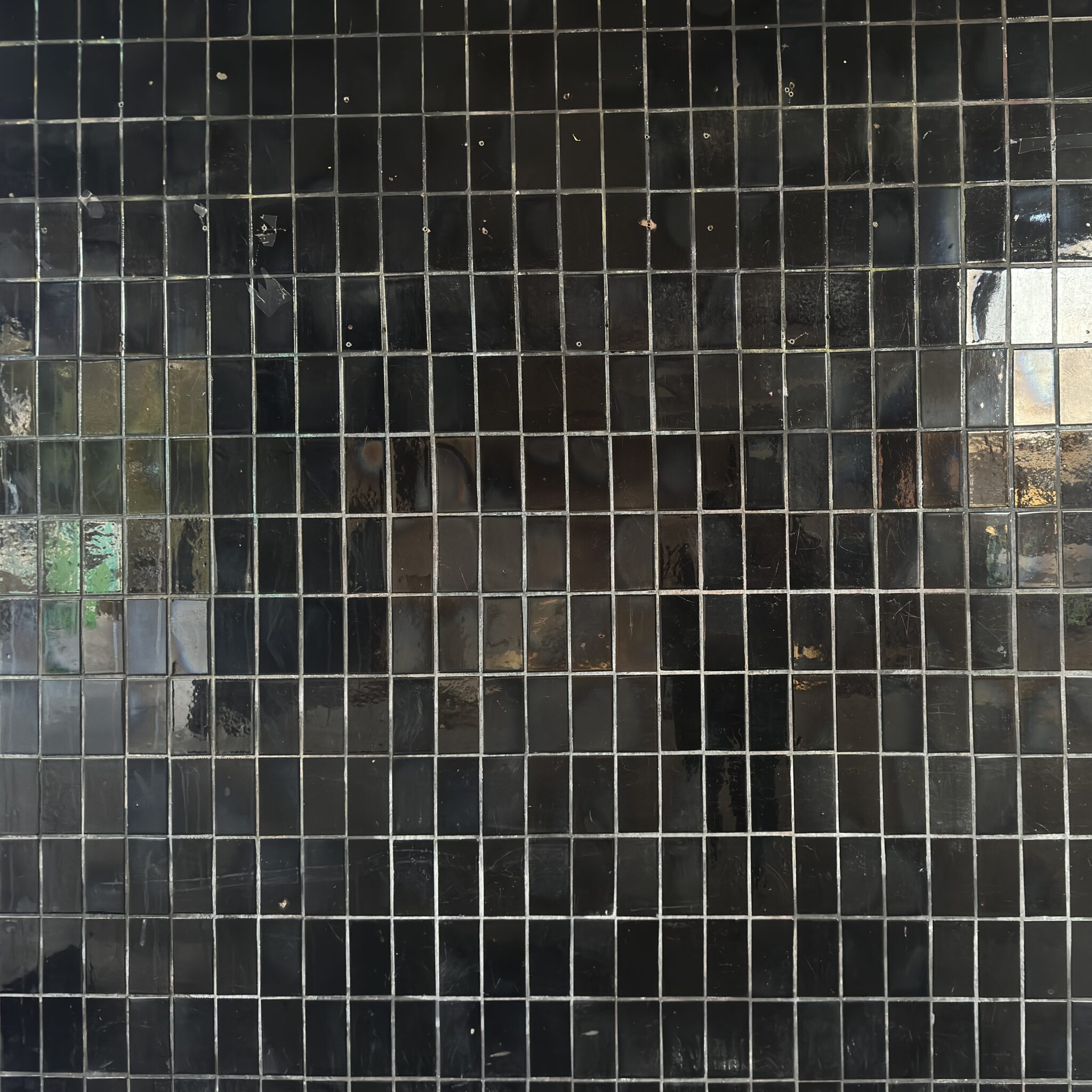 Must seinaosa väikeste ruudukujuliste plaatidega.