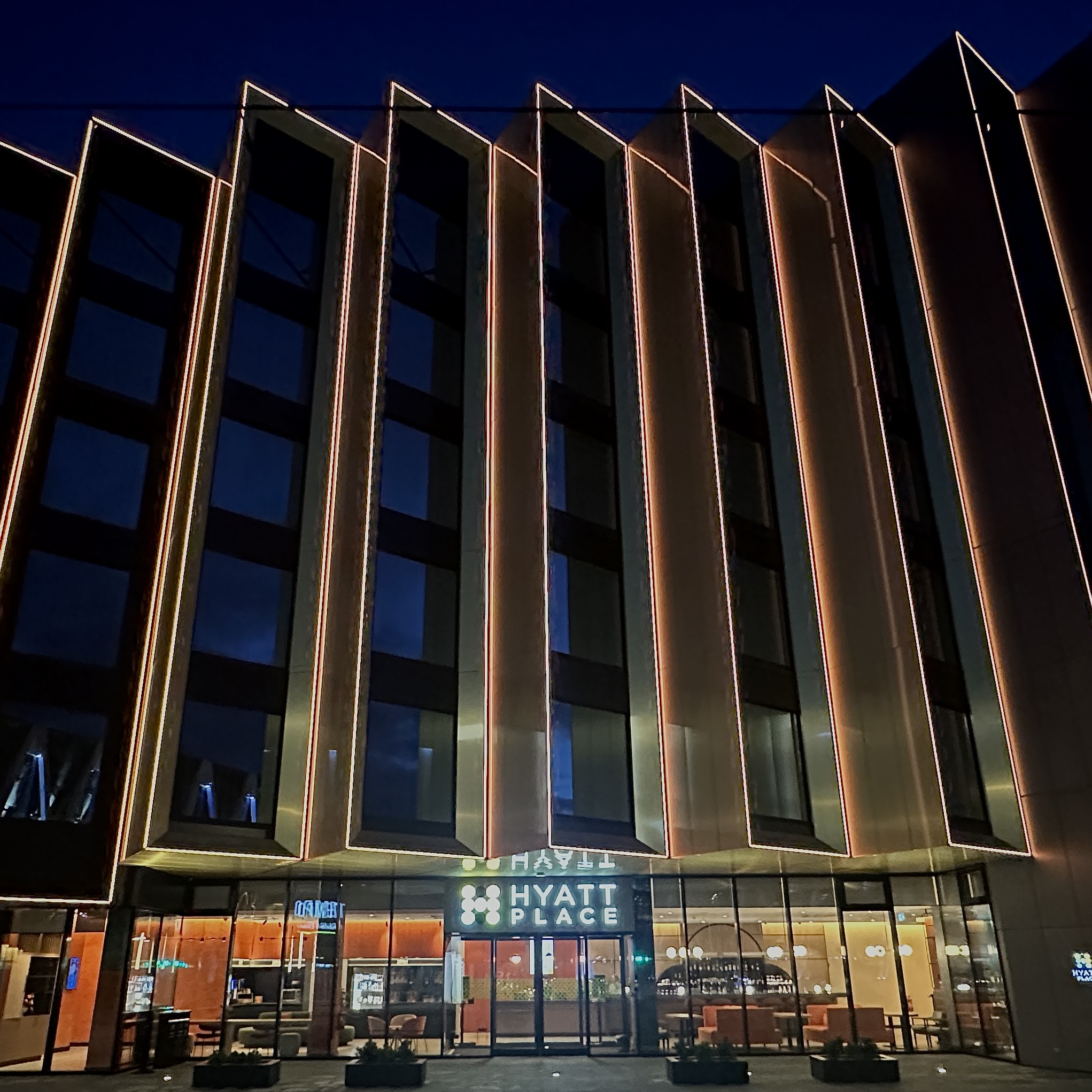 Hyatt Place hotell öösel valgustatud fassaadiga.