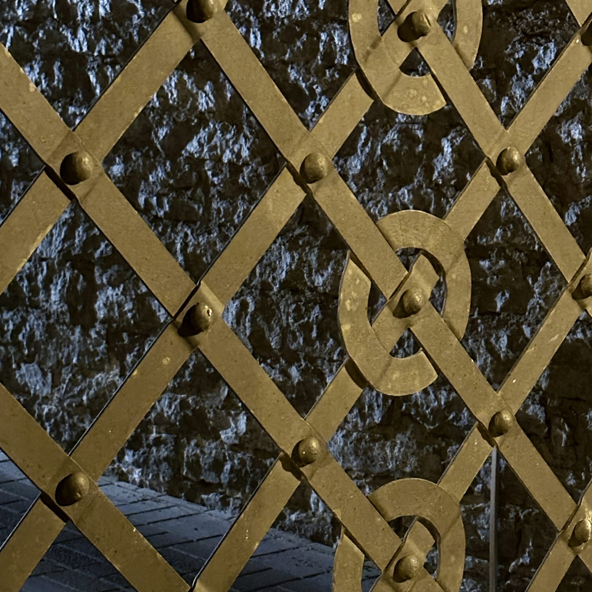 Metallvõrest värav, mille taga kivisein.