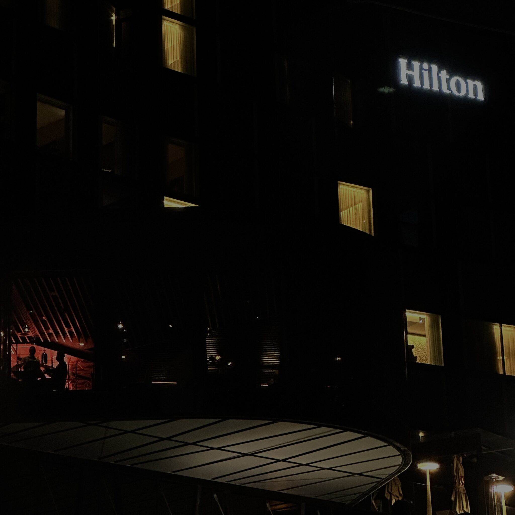 Hilton hotell öösel, valgustatud sildiga.