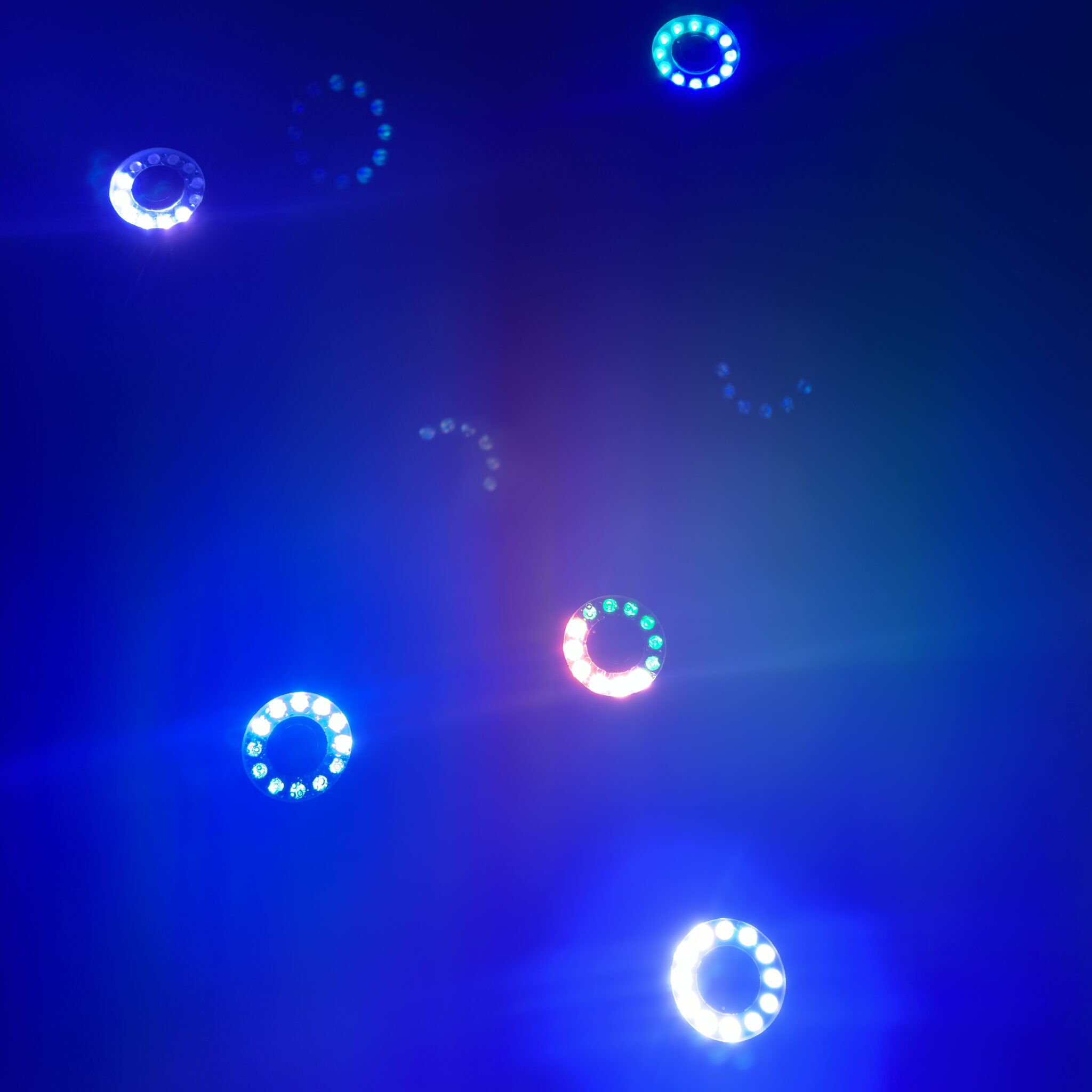 Sinised ja valged ringikujulised tuled tumedal taustal.