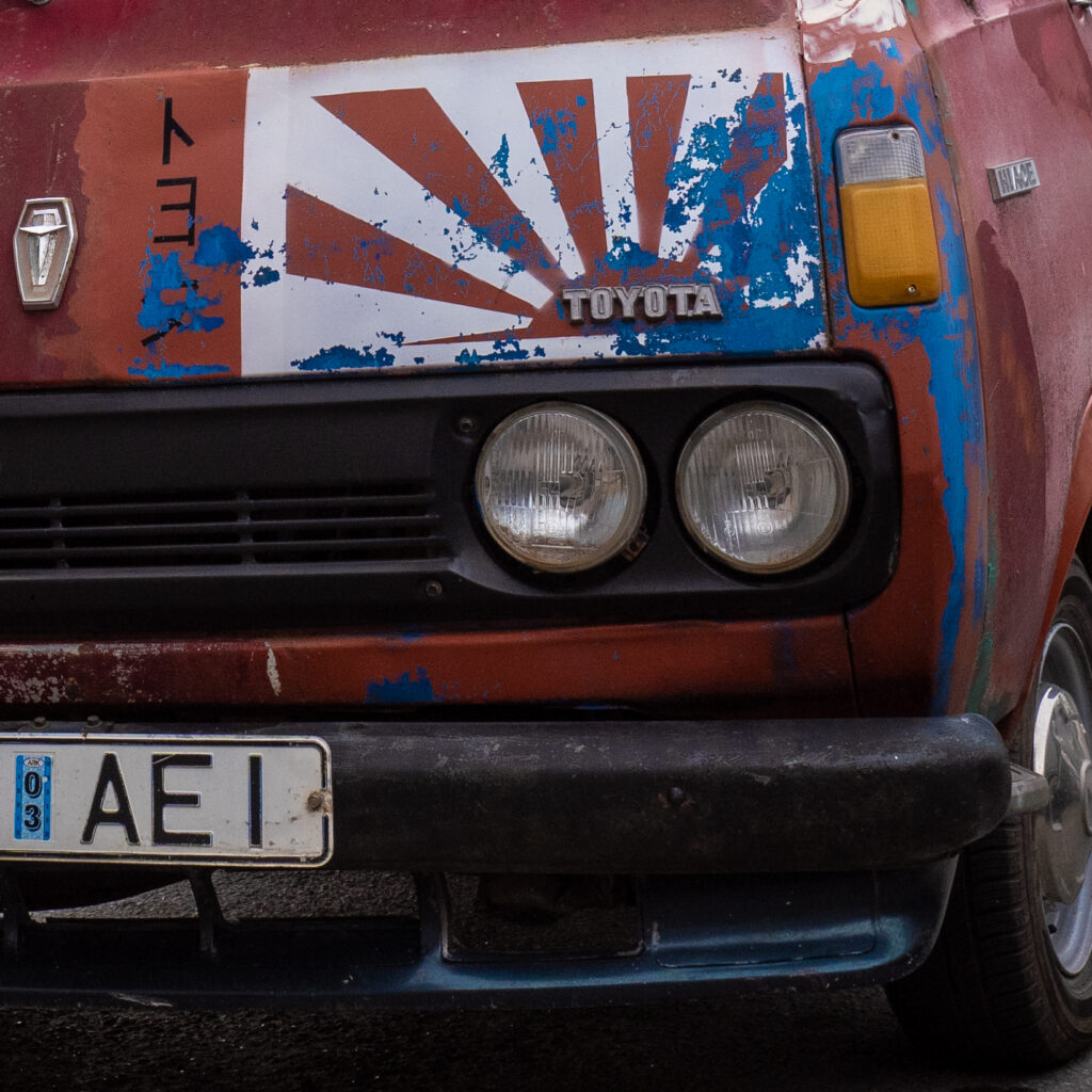 Vana Toyota kaubik Jaapani lipuga esiküljel.