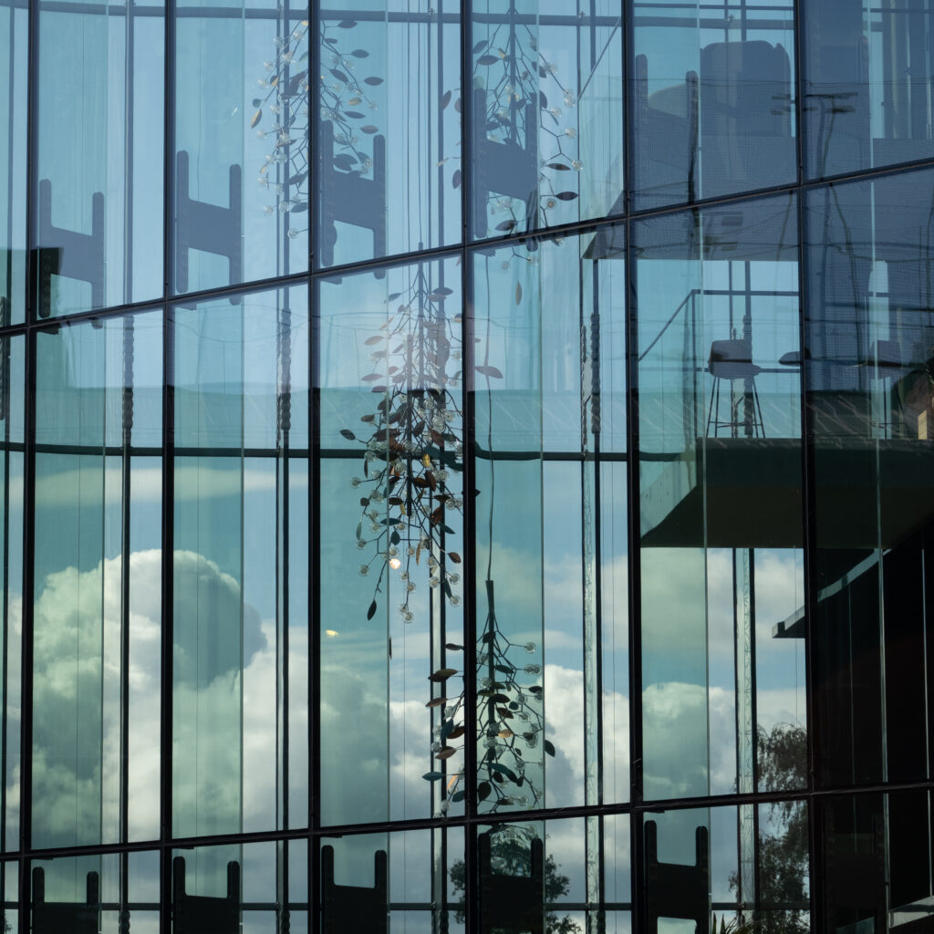 Klaasfassaad peegeldab pilvi ja taevast.