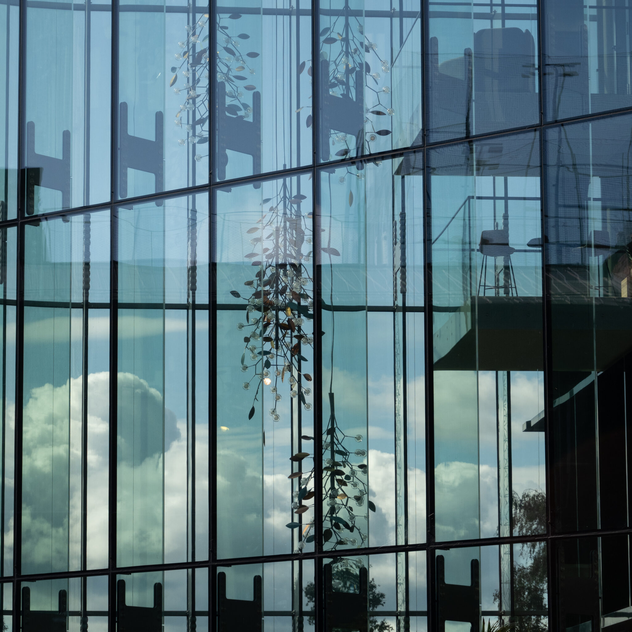 Klaasfassaad peegeldab pilvi ja taevast.