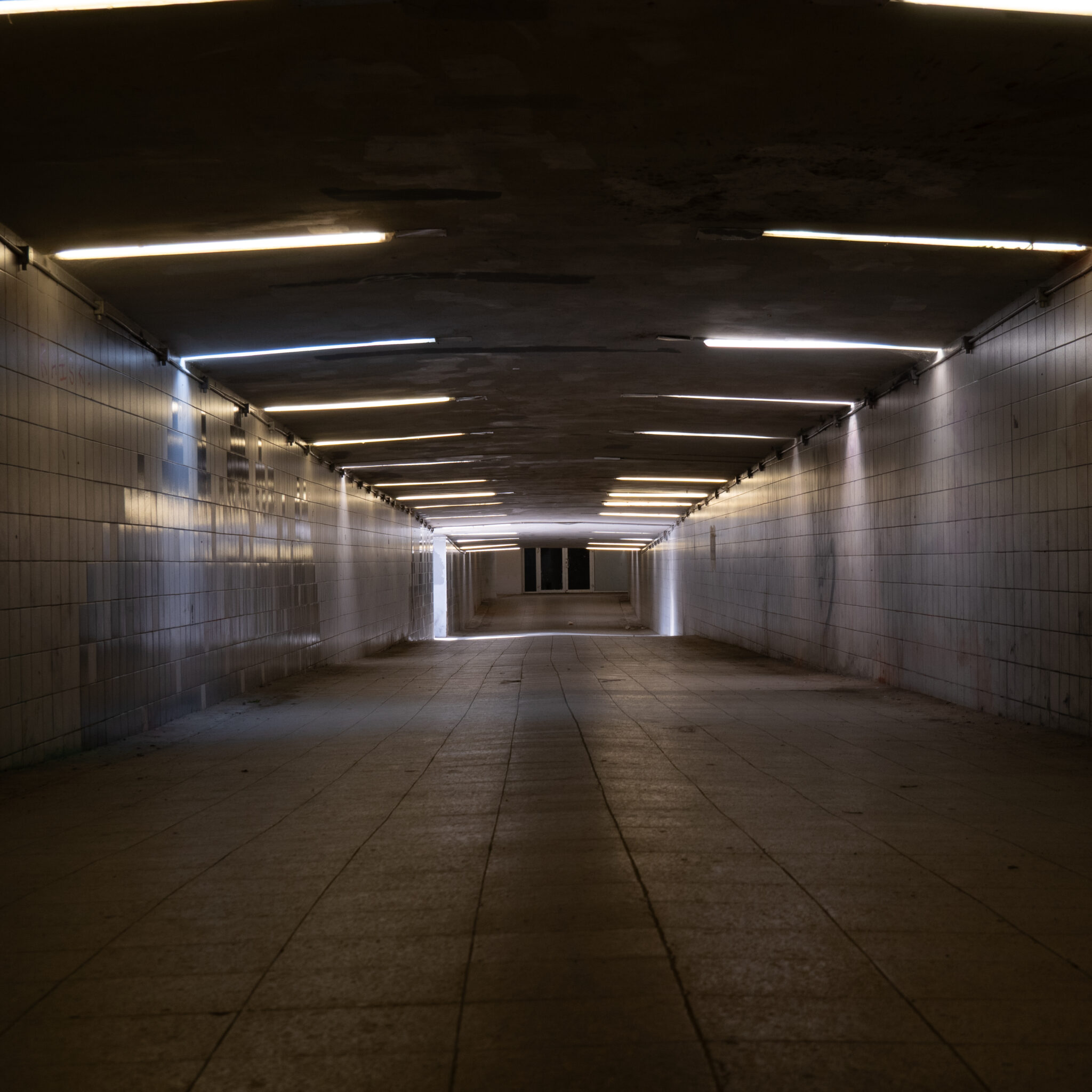 Pikk tume tunnel luminofoorlampidega.