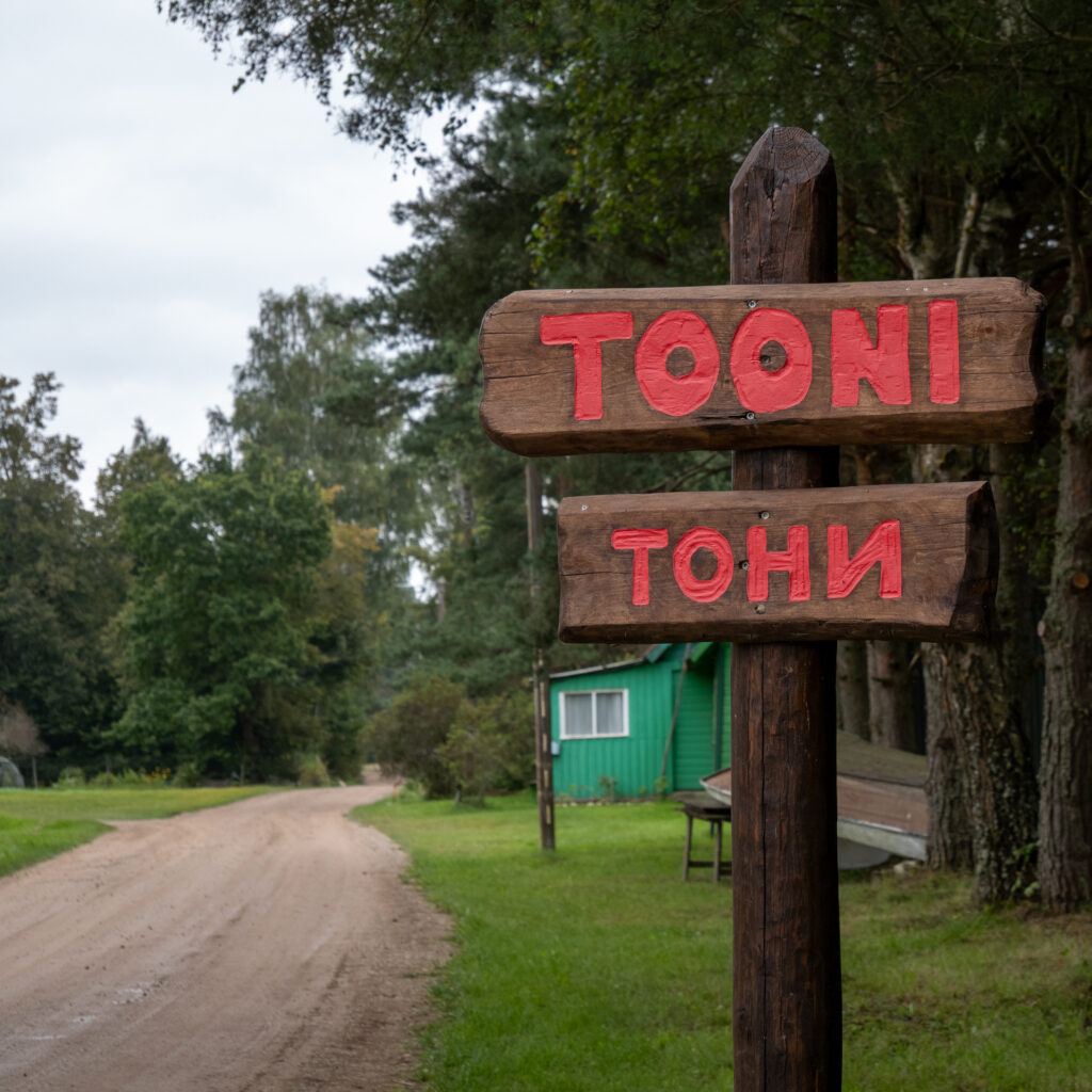 Puidust teeviit tekstiga „Tooni” ja „Tooni” metsases alas.