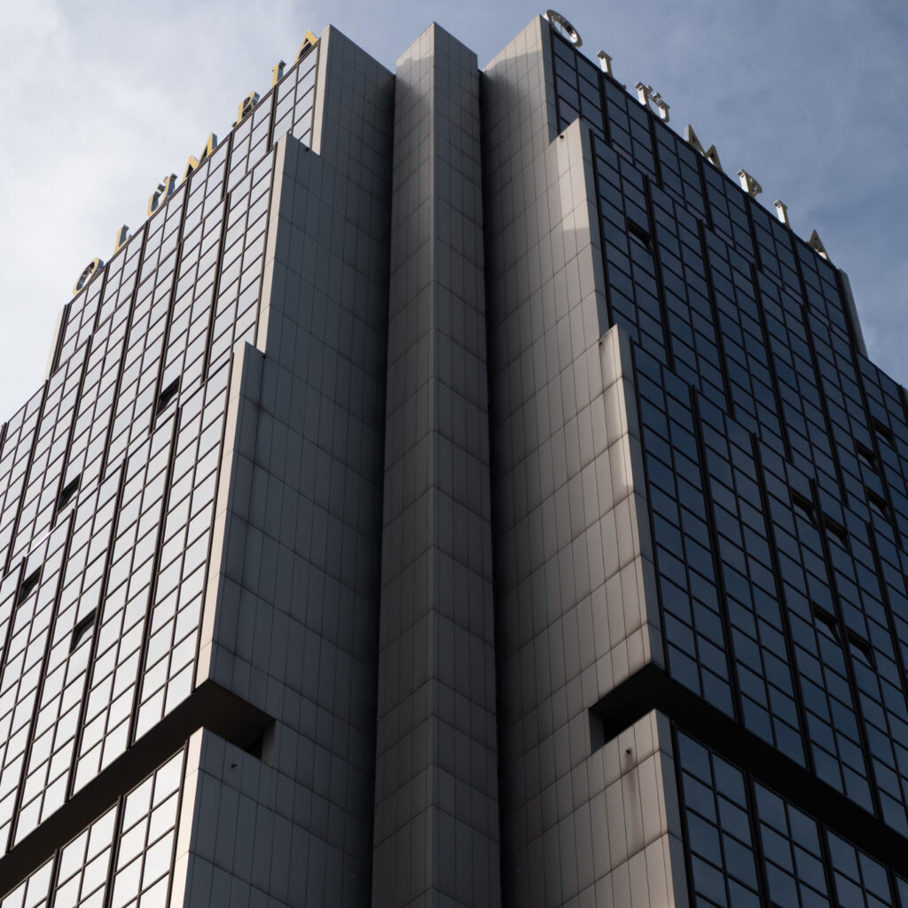 Kõrge moodne hoone kirjaga „OLYMPIA” fassaadil.