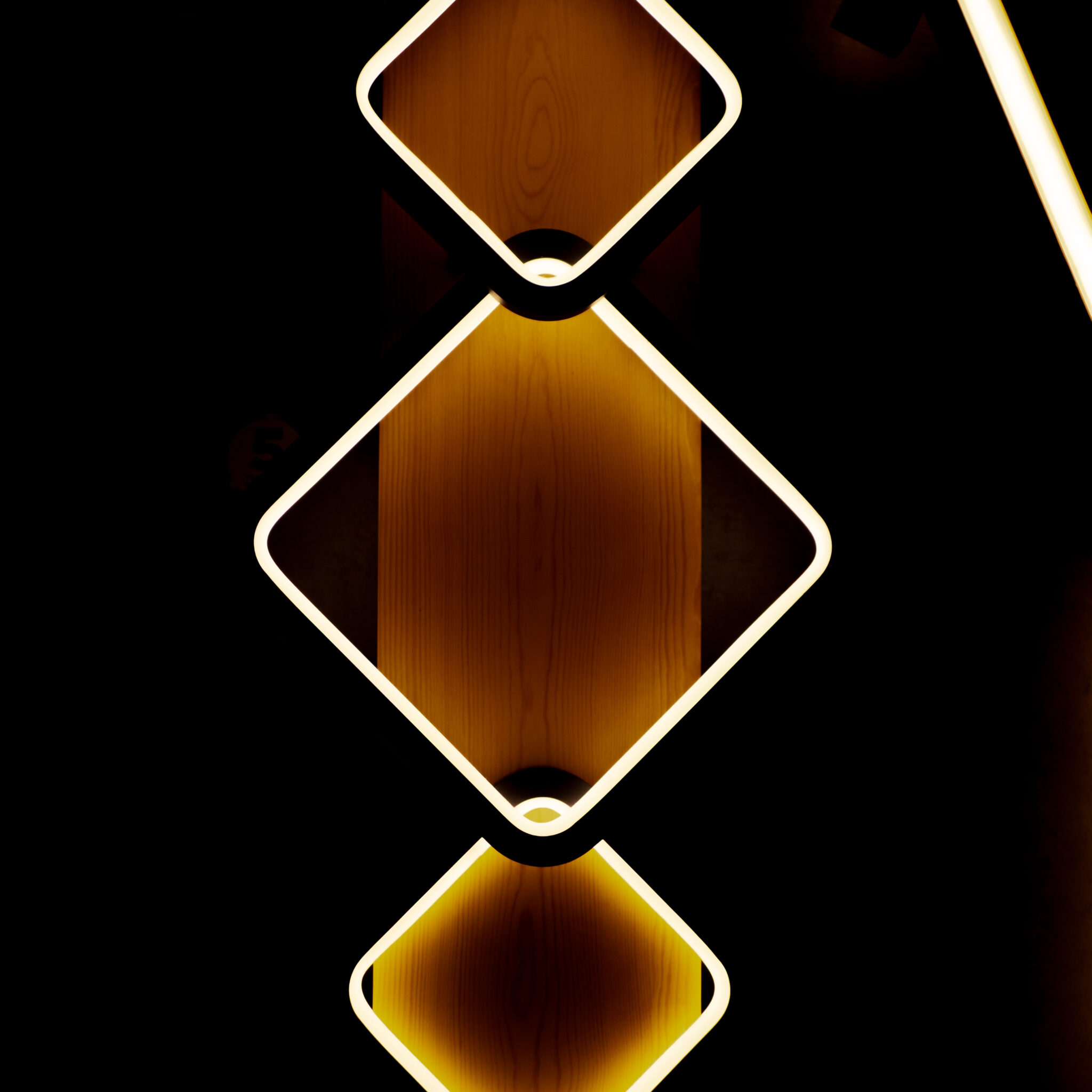 Kolm valgustatud teemantkuju mustal taustal.