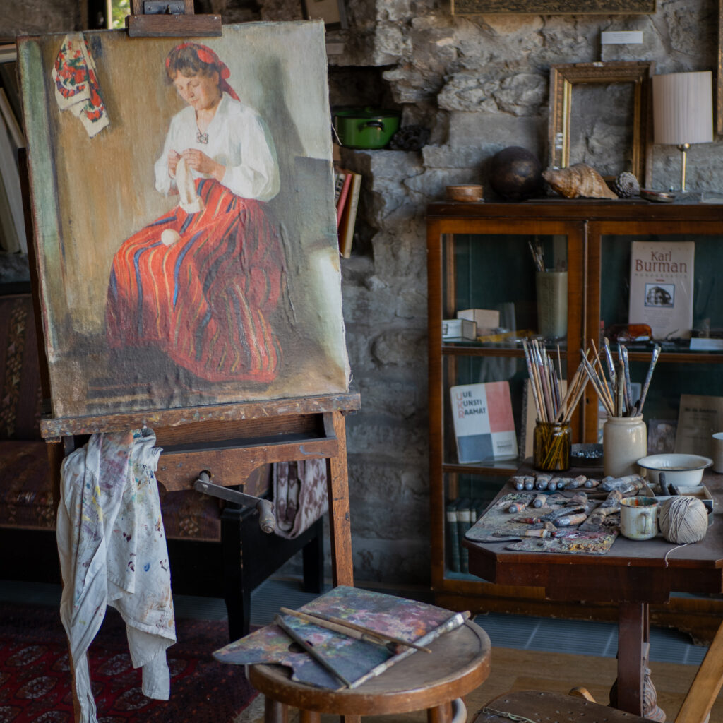 Kunstistuudio maaliga naisest, tööriistad ja raamatud.