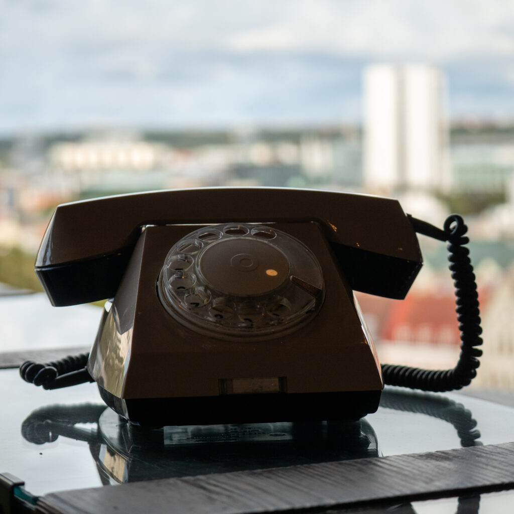 Vanaaegne telefon laual, taustal linnavaade.