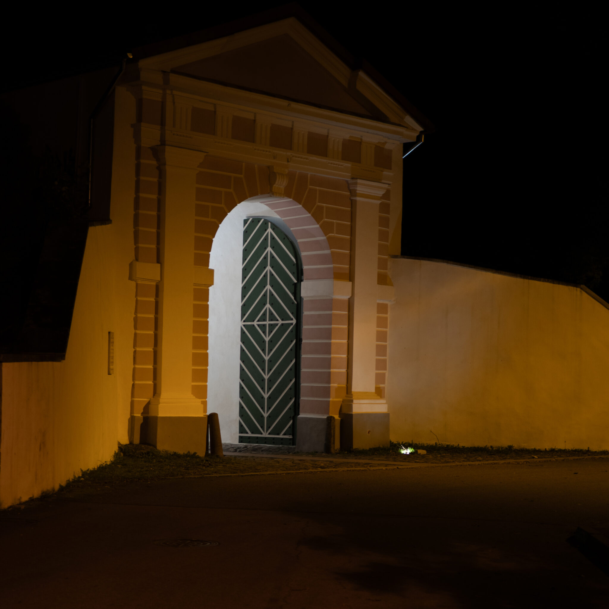 Ajalooline hoone rohelise uksega, valgustatud öösel.