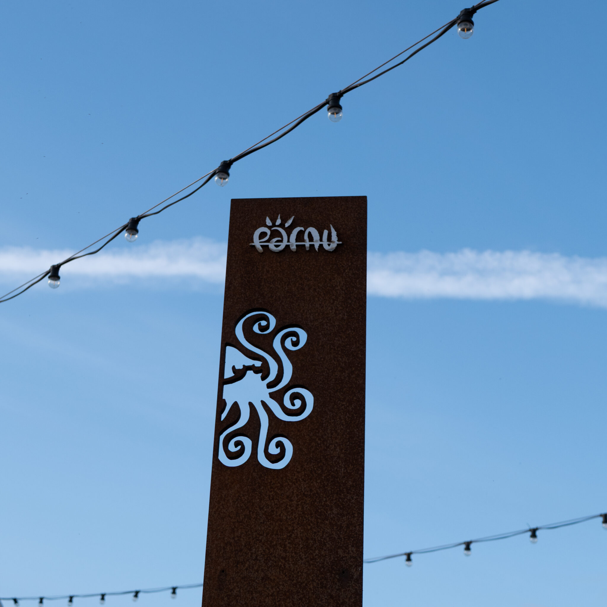 Kõrge silt kaheksajalakujulise logoga ja kirjaga „Pärnu” sinise taeva taustal.