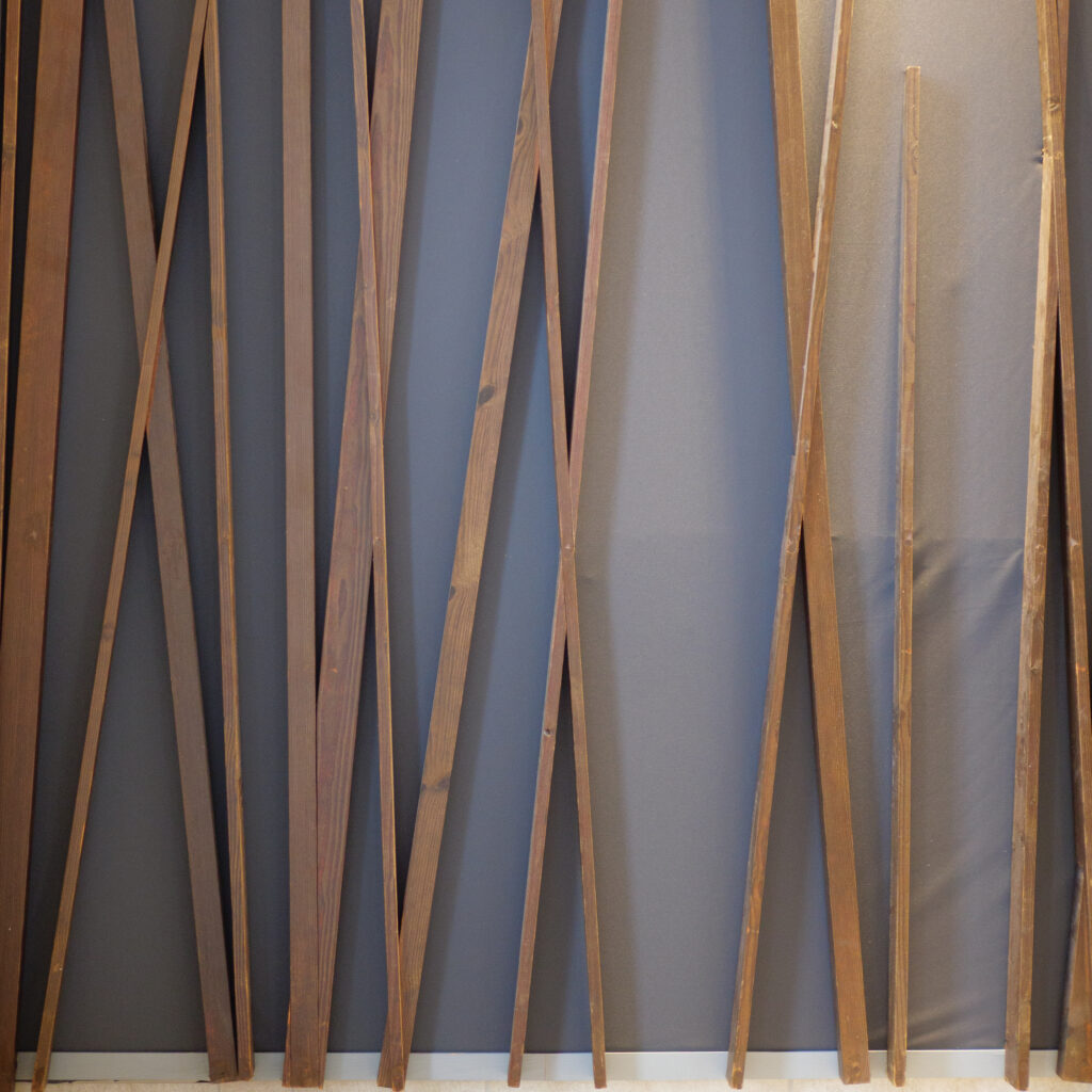 Puidust liistud tumeda seina taustal.