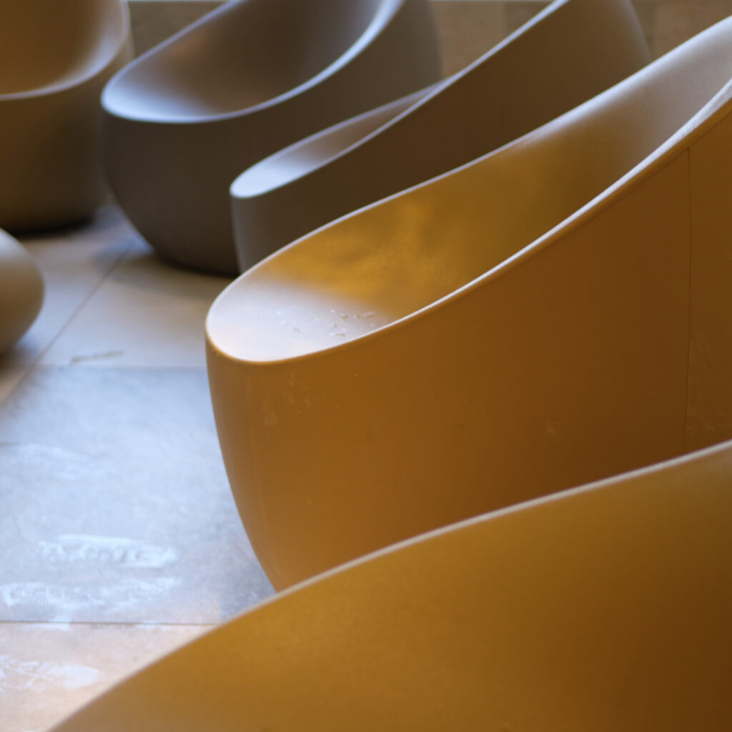 Rida kaasaegseid kumeraid kollaseid ja beeže toole.