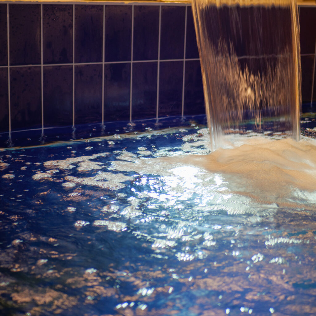 Vesi voolab siniste plaatidega basseini.