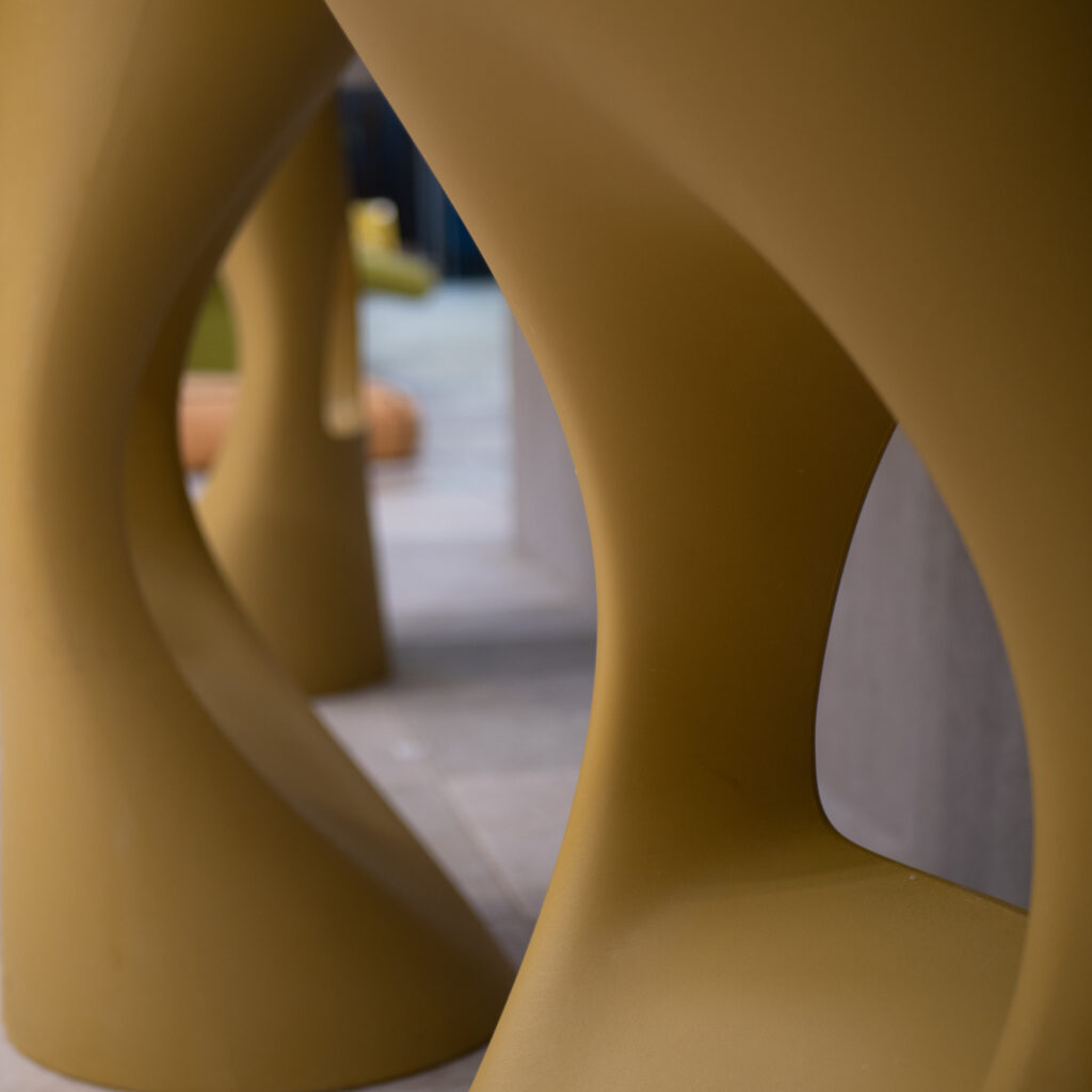 Kaks kollast modernset lainelist taburetti ruumis.