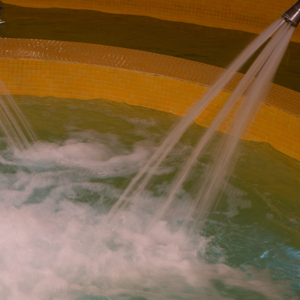 Vesi voolab kollaste plaatidega basseini.