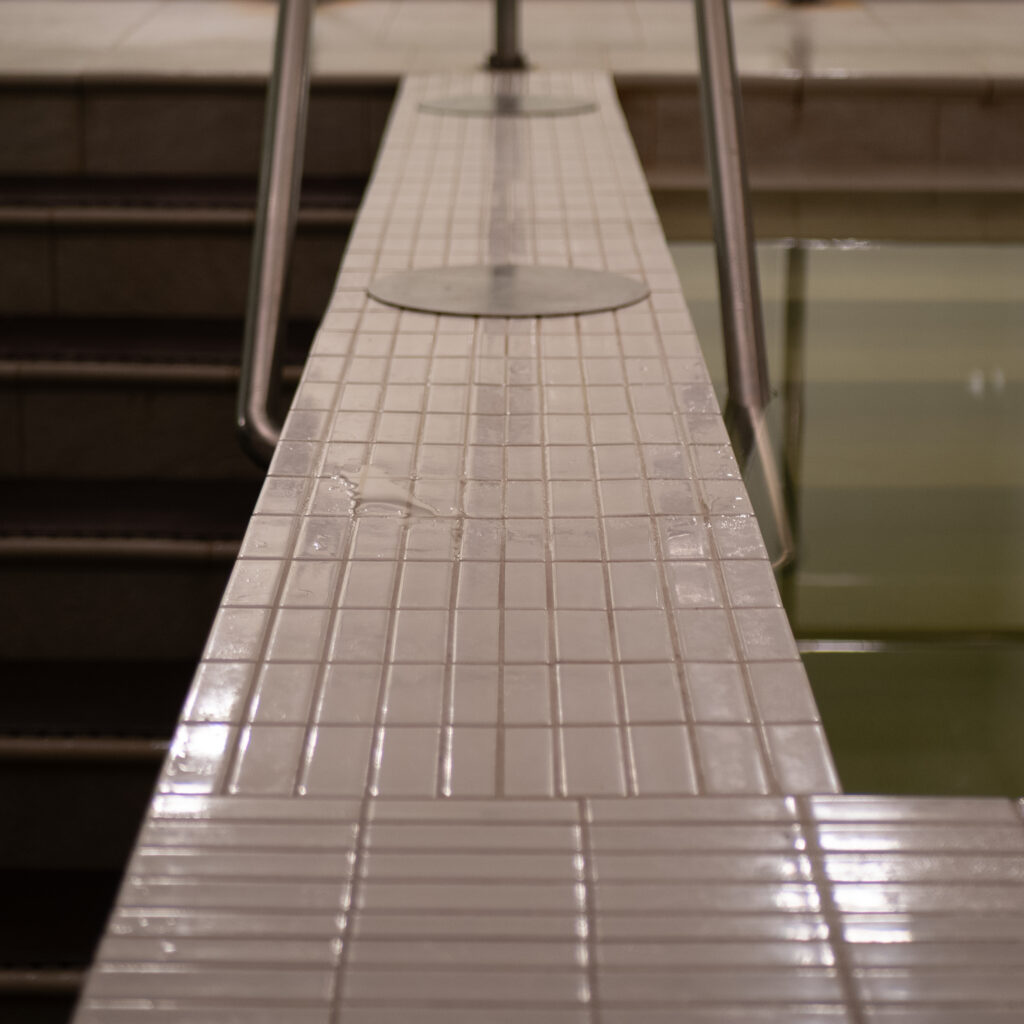 Plaaditud basseini serv metallpiirdega.