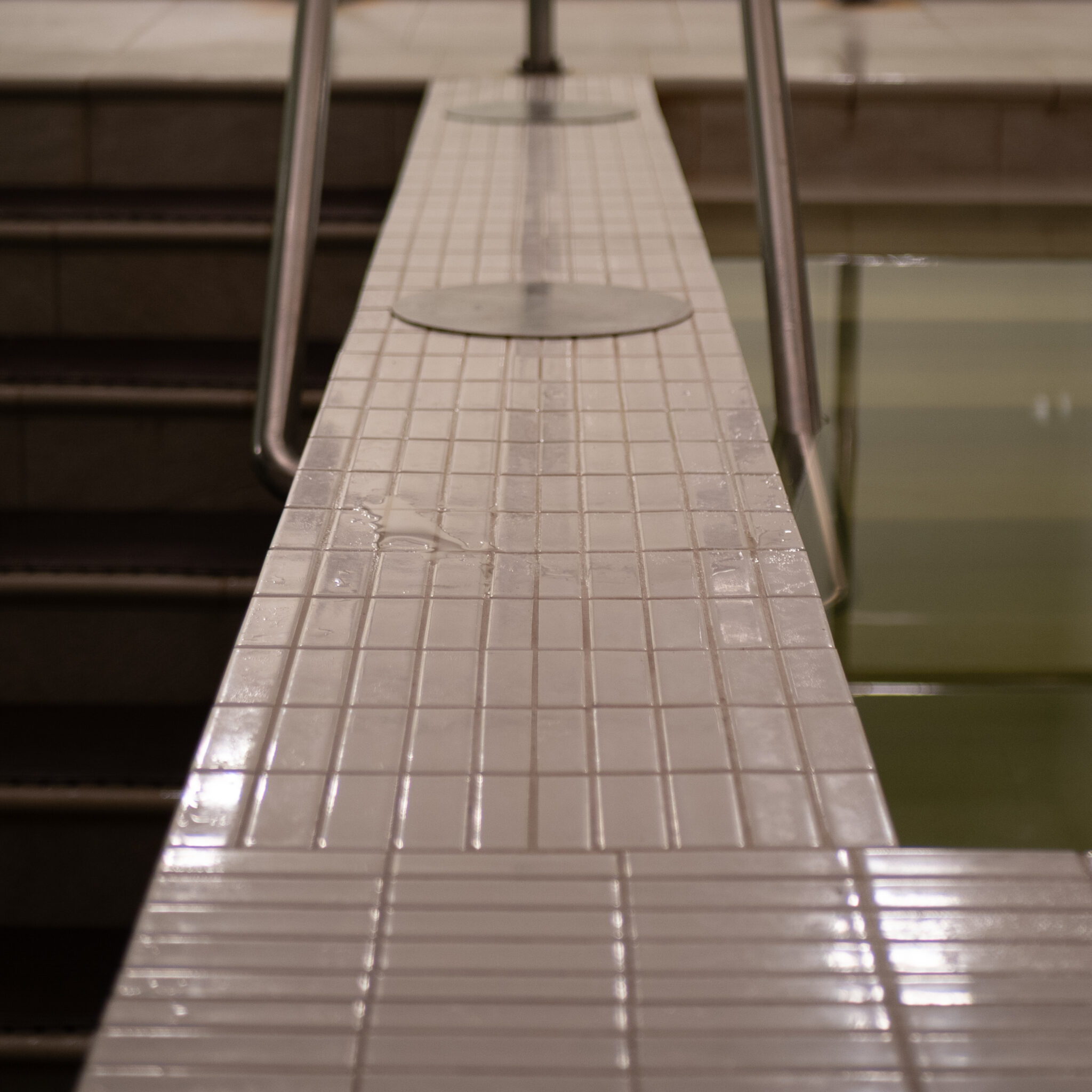 Plaaditud basseini serv metallpiirdega.