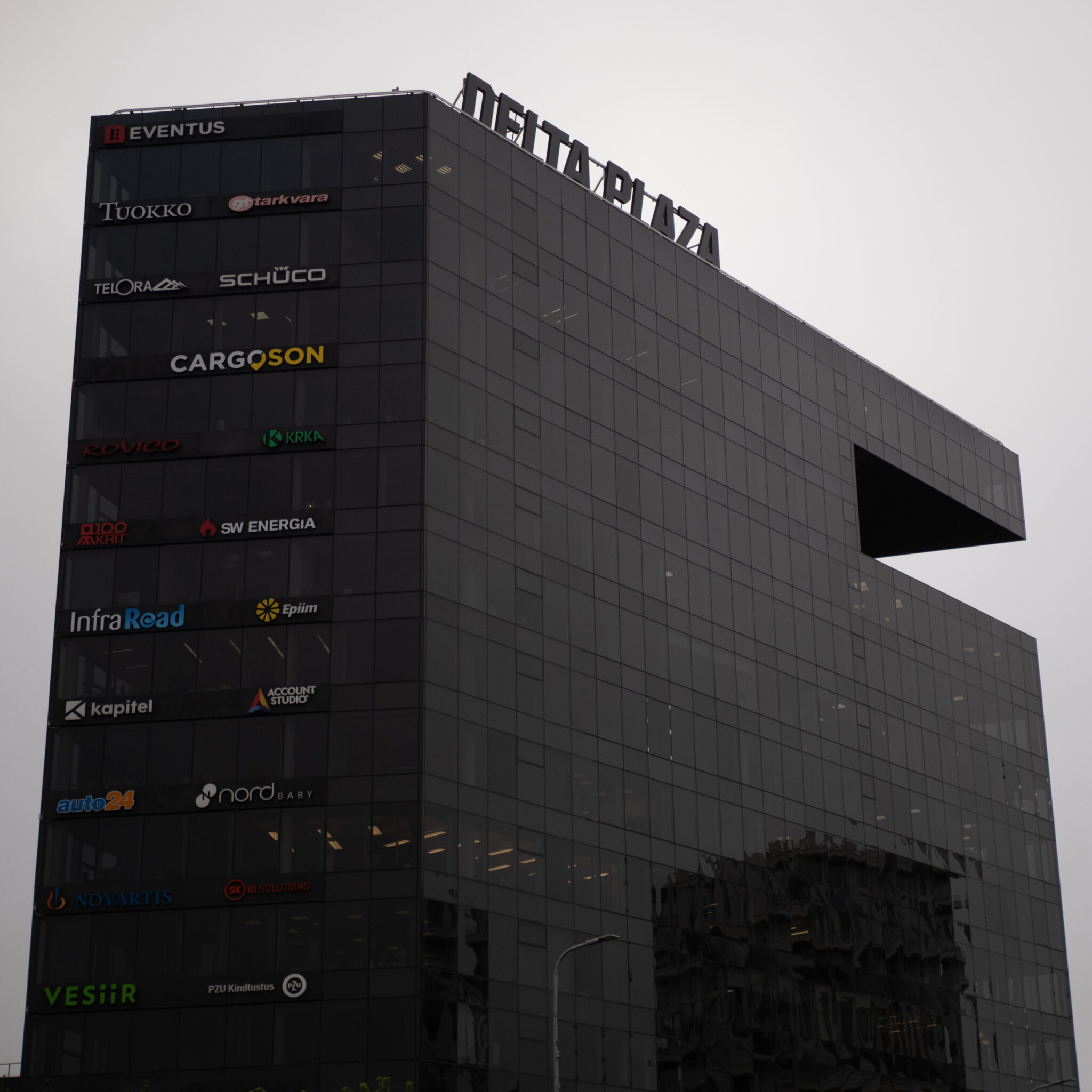 Delta Plaza hoone koos ettevõtete logodega fassaadil.