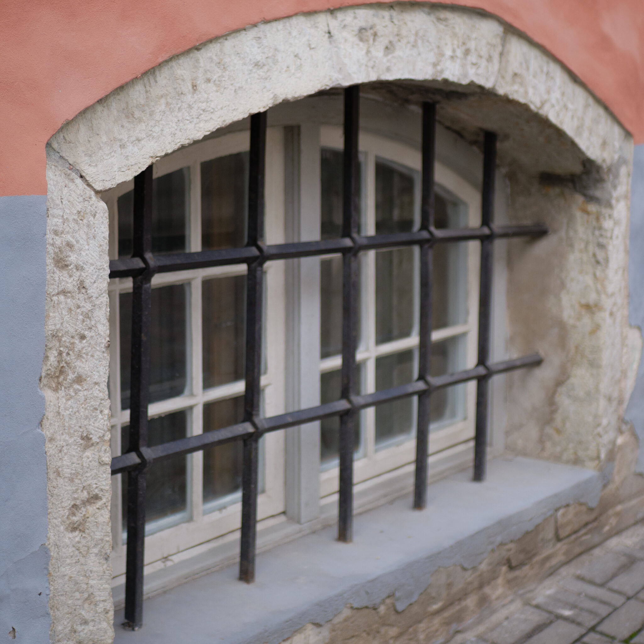 Aken metallvõrega ja kivikaare all.