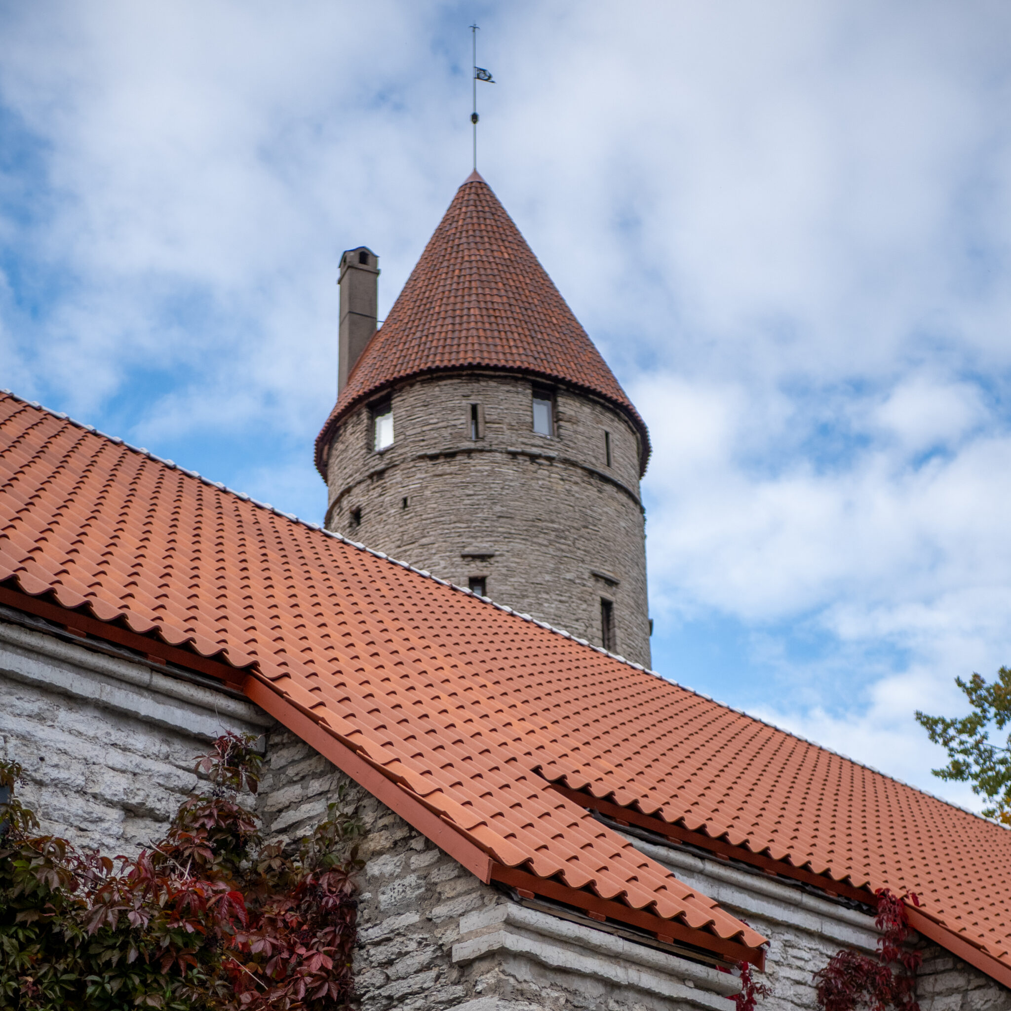 Ajalooline torn punase kivikatusega pilvise taeva taustal.