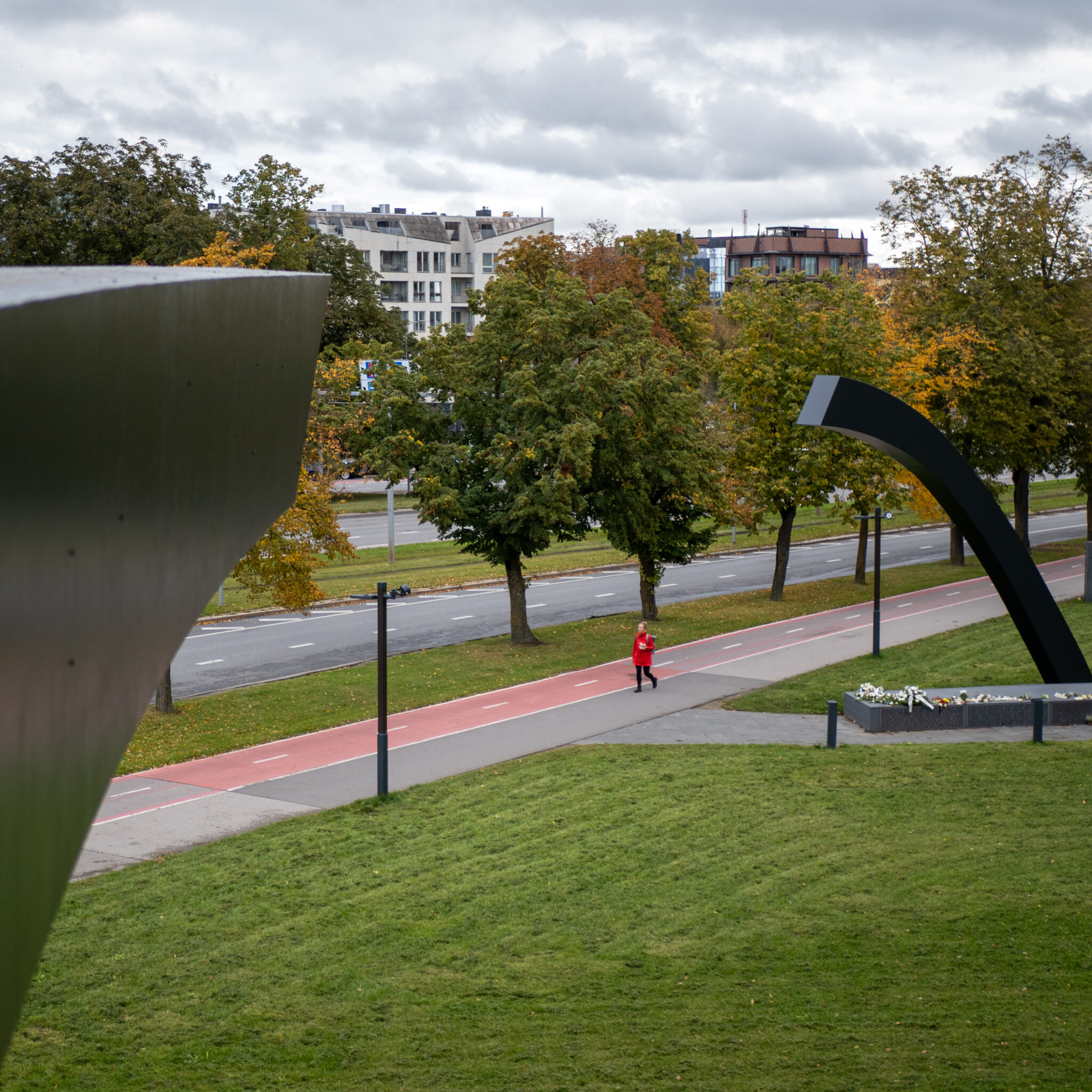 Jooksja punases jakis punasel kergliiklusteel pargis.