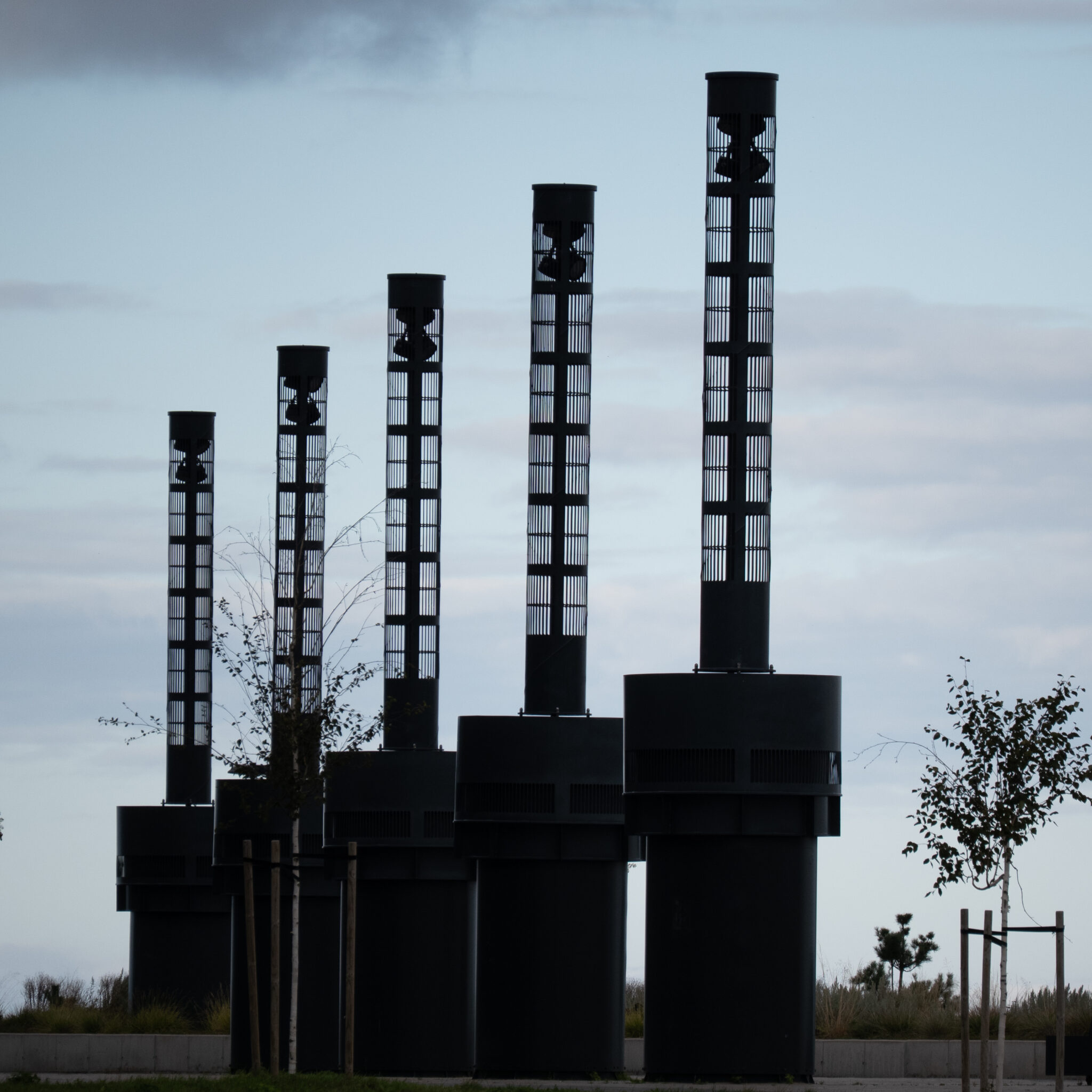 Neli musta silindrilist torni ruudulise mustriga.