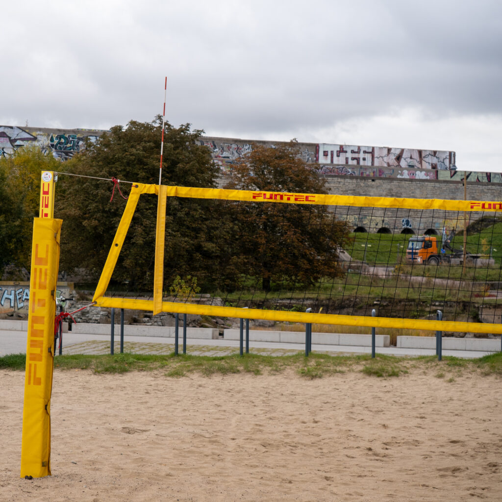 Rannavõrkpalli võrk kollaste postide ja punavalge võrguga.
