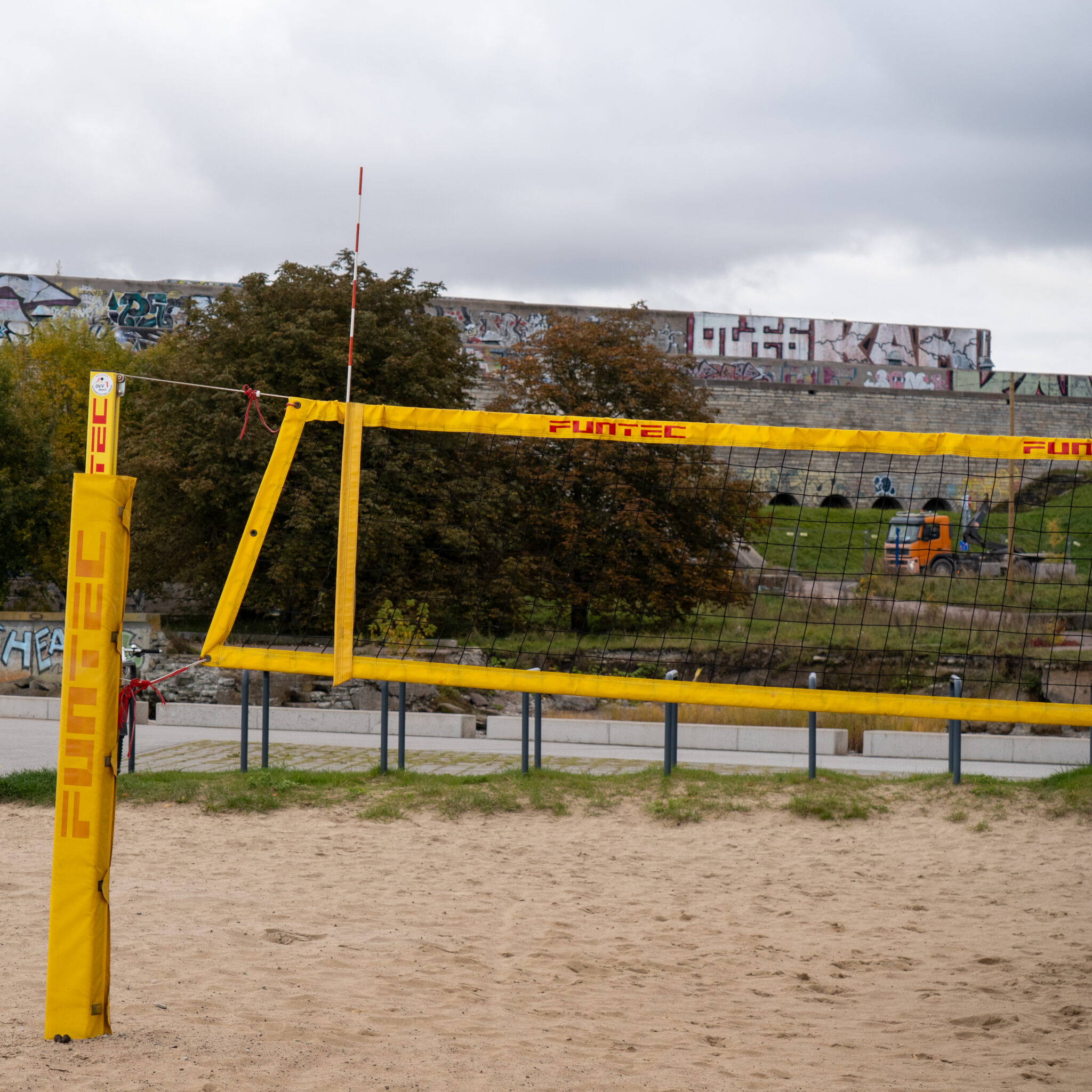 Rannavõrkpalli võrk kollaste postide ja punavalge võrguga.