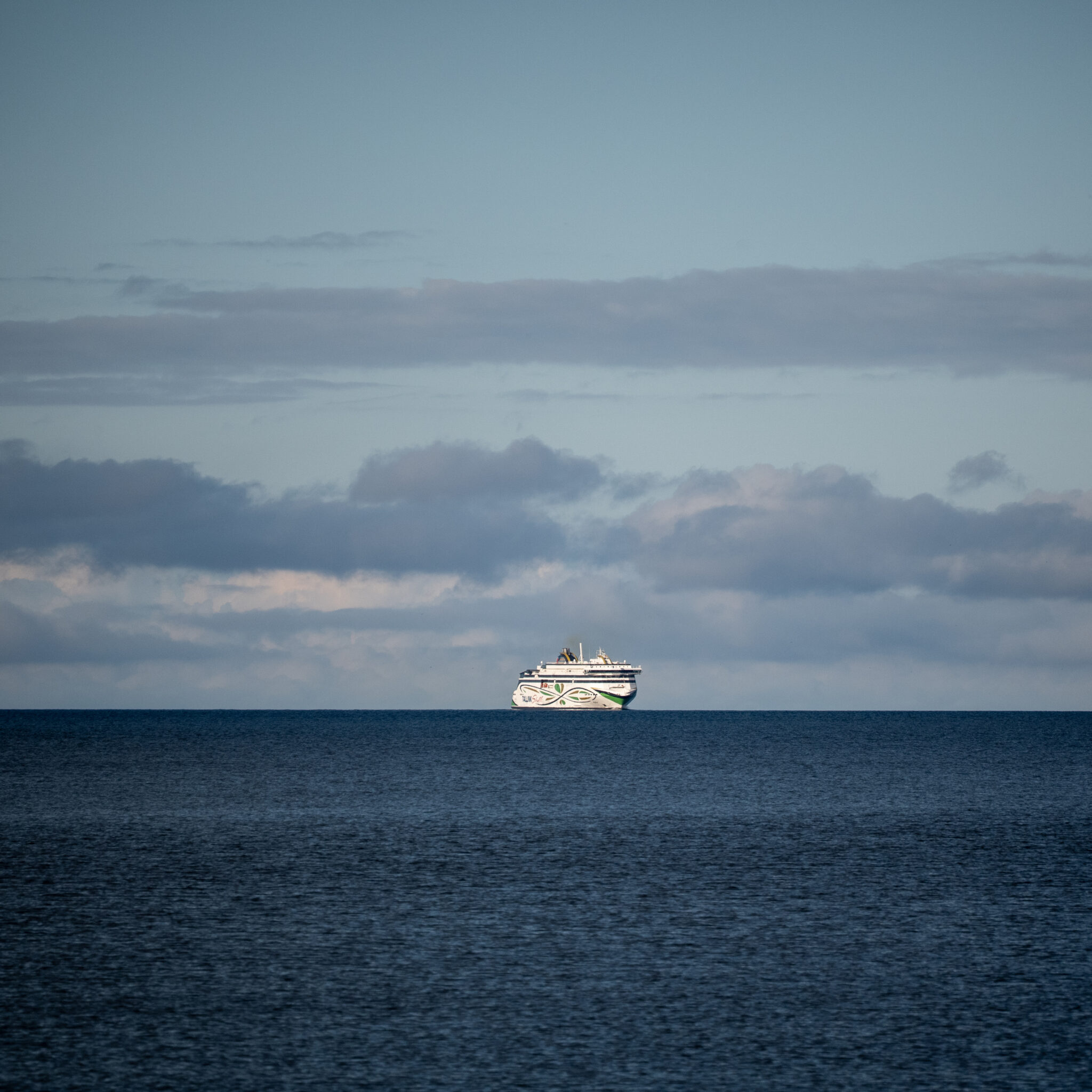 Kruiisilaev silmapiiril pilvise taeva all.