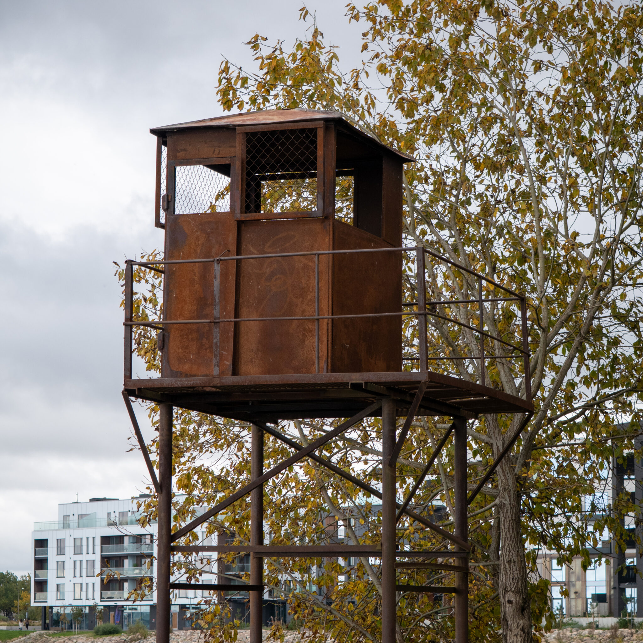 Rustikaalne vahitorn sügiseses vaates, taustal modernsed hooned.