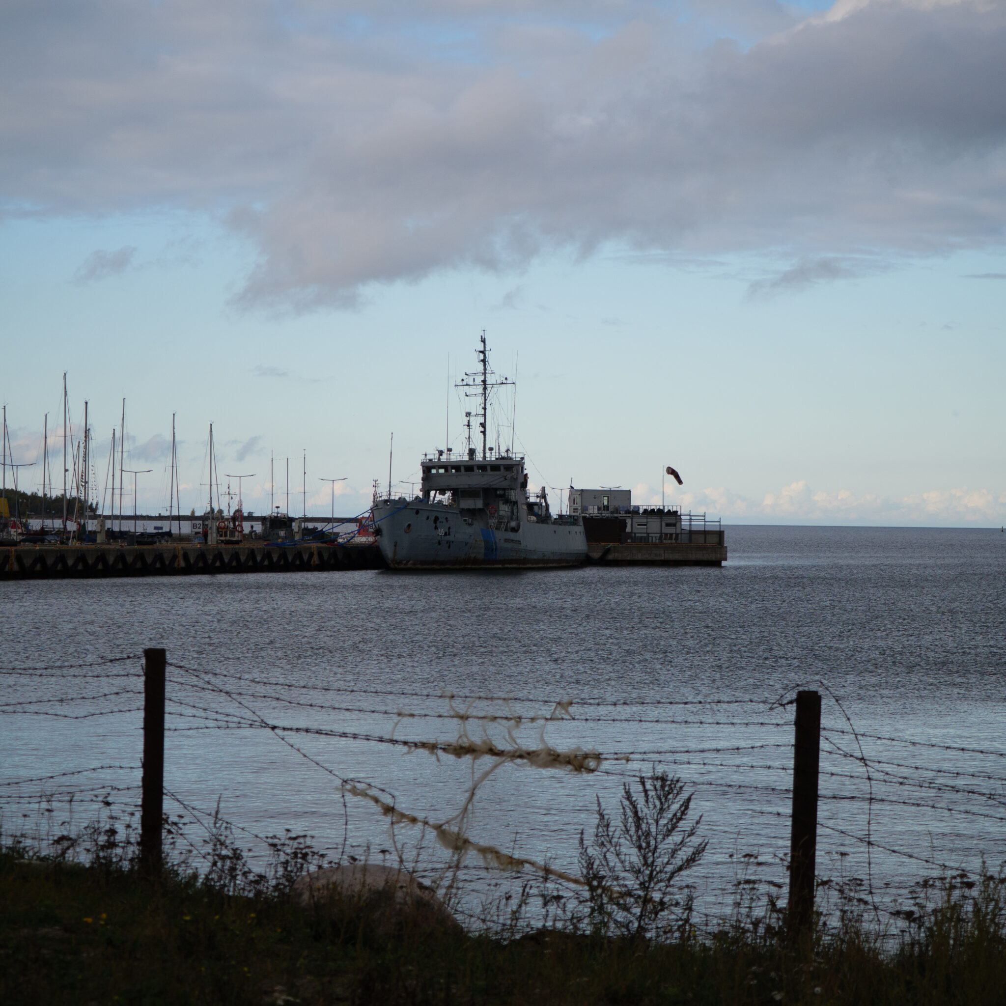 Laev dokis sadamas pilvise taeva all.