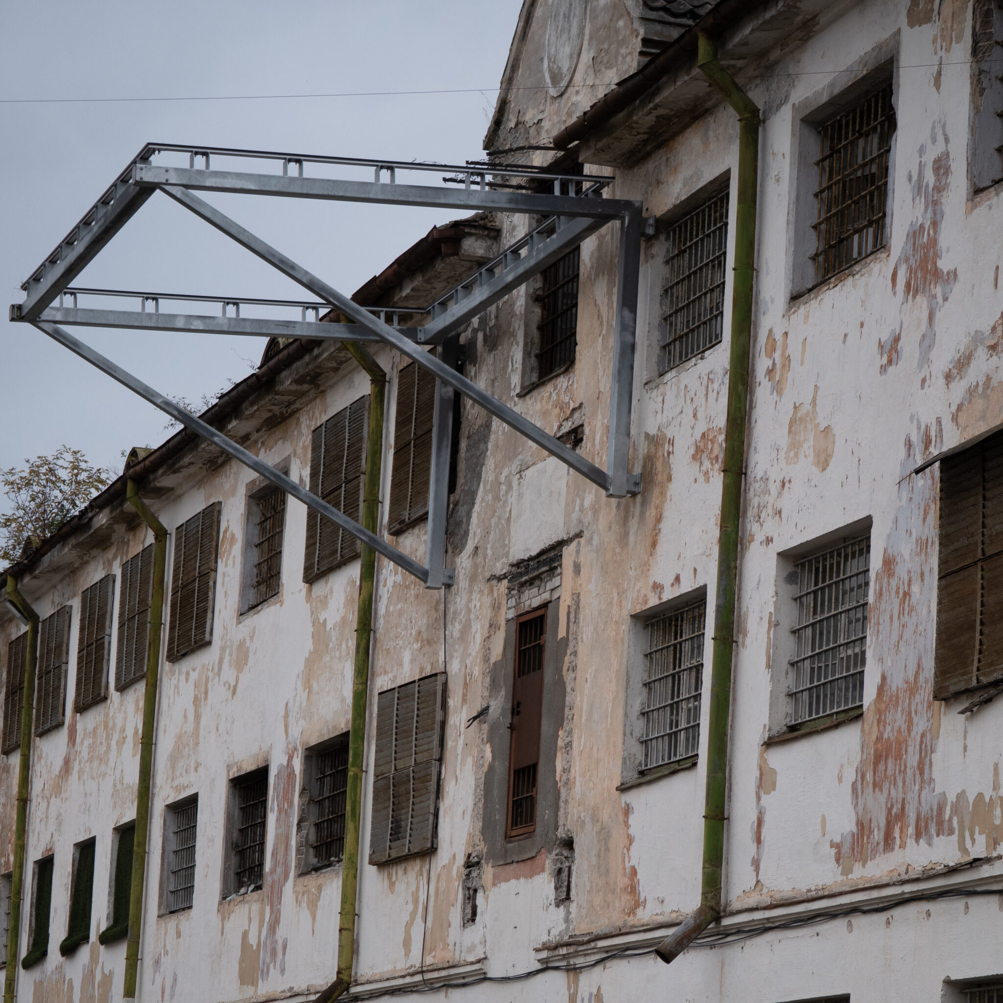 Vana lagunenud hoone metallkonstruktsiooni ja trellitatud akendega.