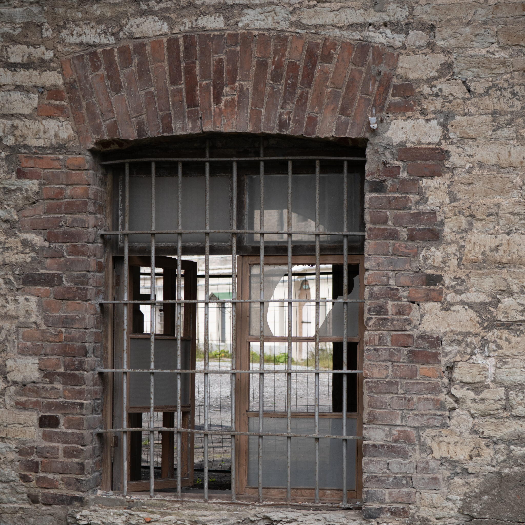 Vana kulunud aken purunenud klaasiga ja metallvõrega.
