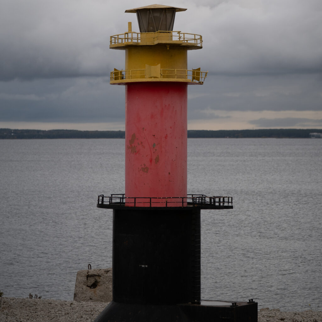 Punane ja kollane tuletorn kivisel rannikul.